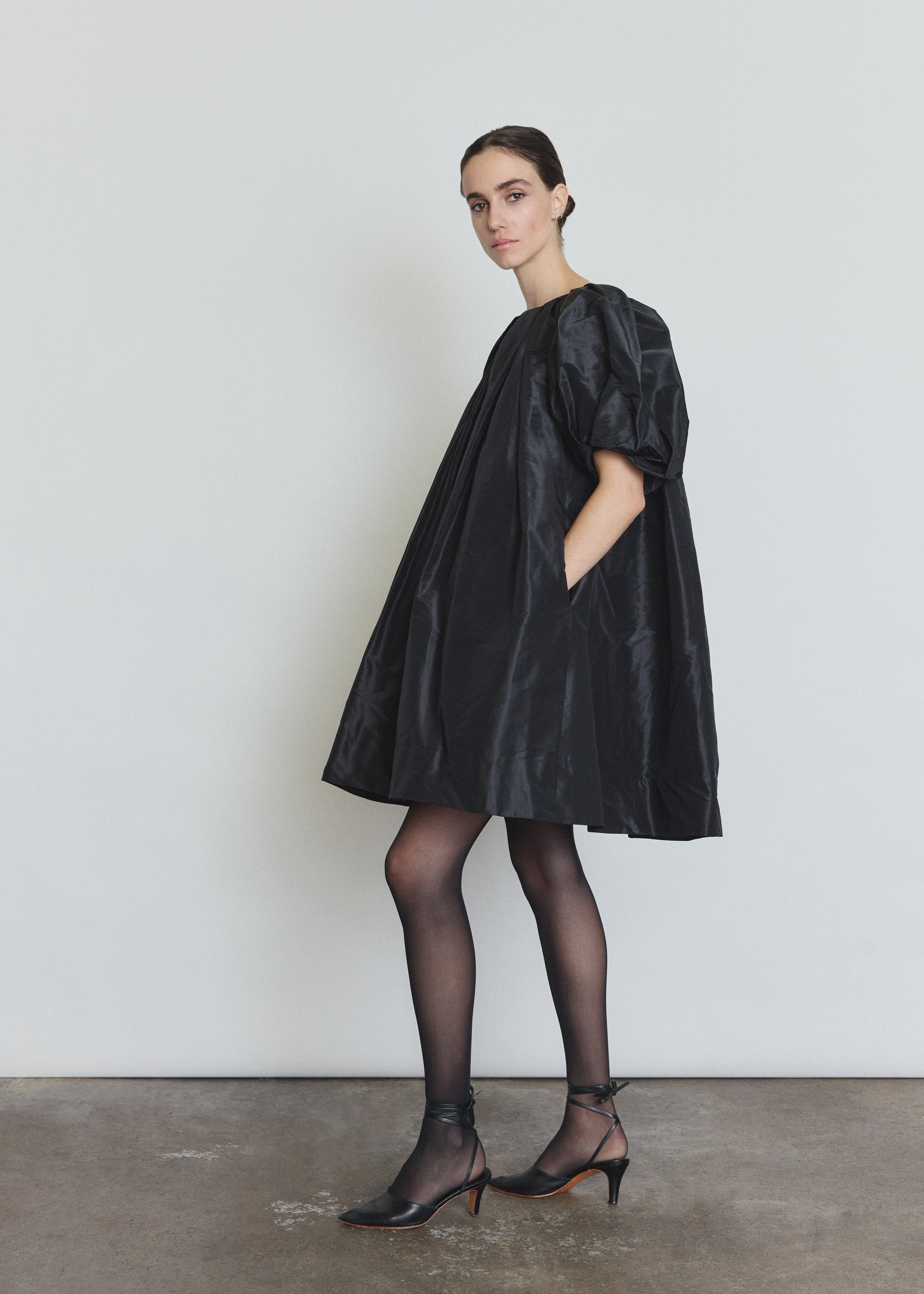 Back view of the black silk taffeta Kamperett Eva Dress showing the pleated sleeves.