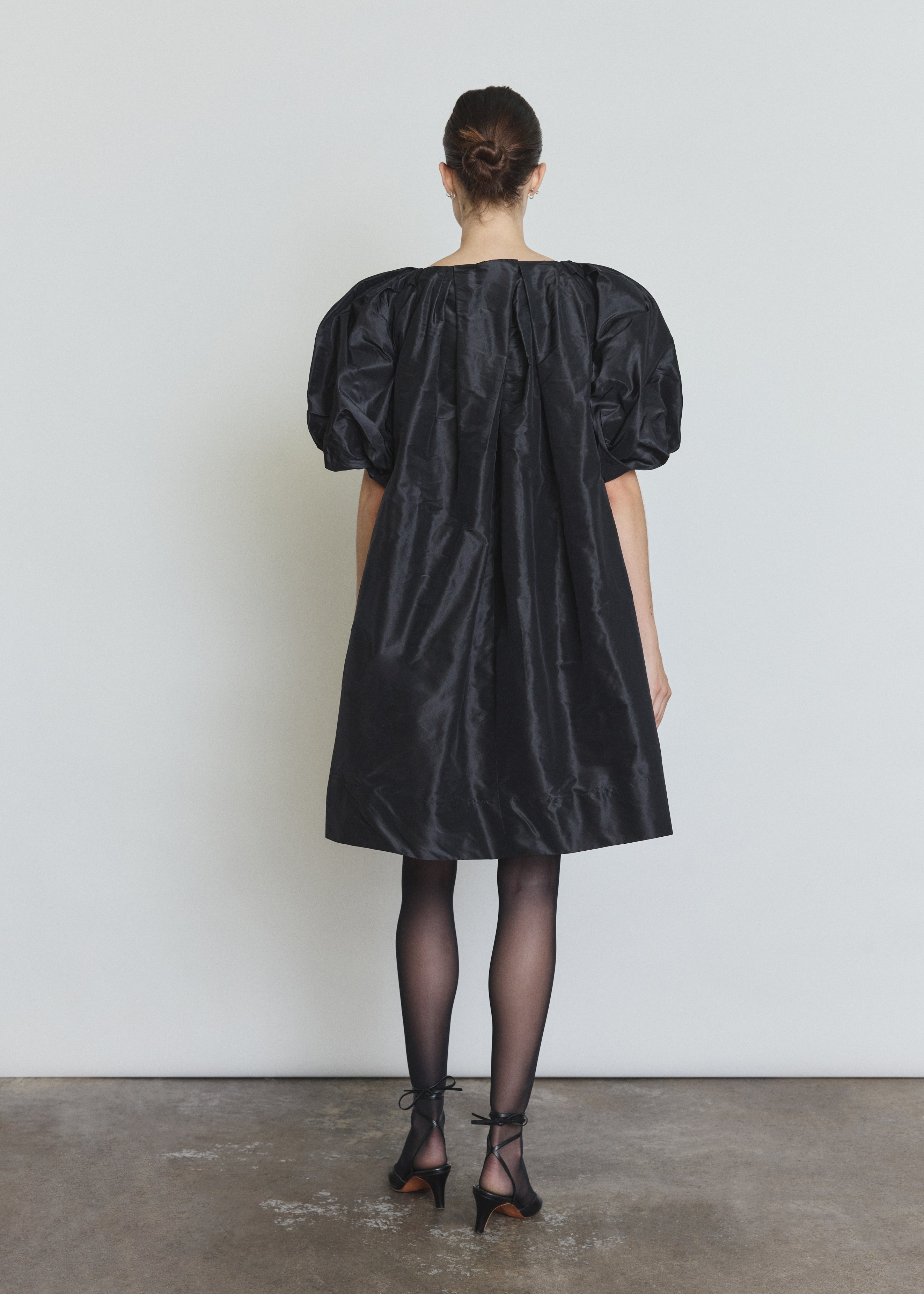Detail of the black silk taffeta Kamperett Eva Dress showing the asymmetrical pleat construction at the neckline.