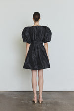 Editorial image of the black Kamperett Eva Dress styled with motion.