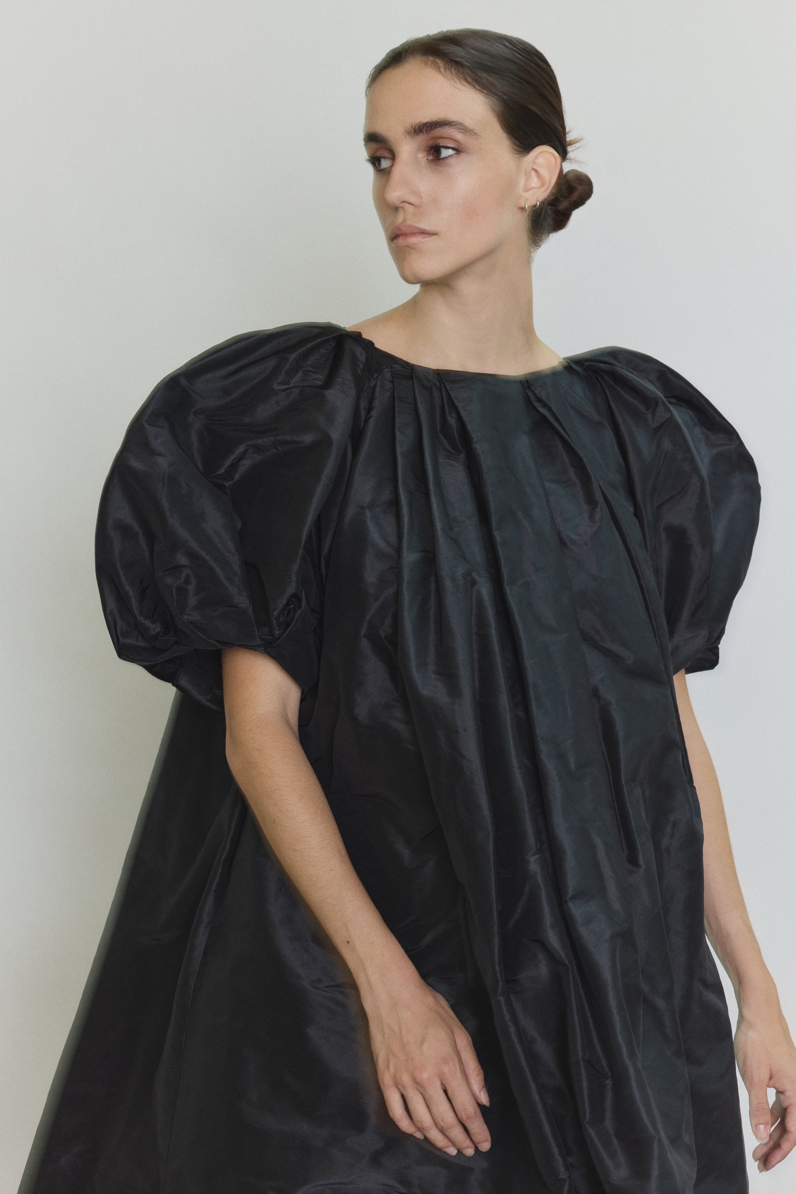 Editorial image of the black Kamperett Eva Dress with the coordinating silk taffeta belt.