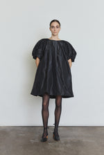 Side view of the black silk taffeta Kamperett Eva Dress showing the full A-line volume.