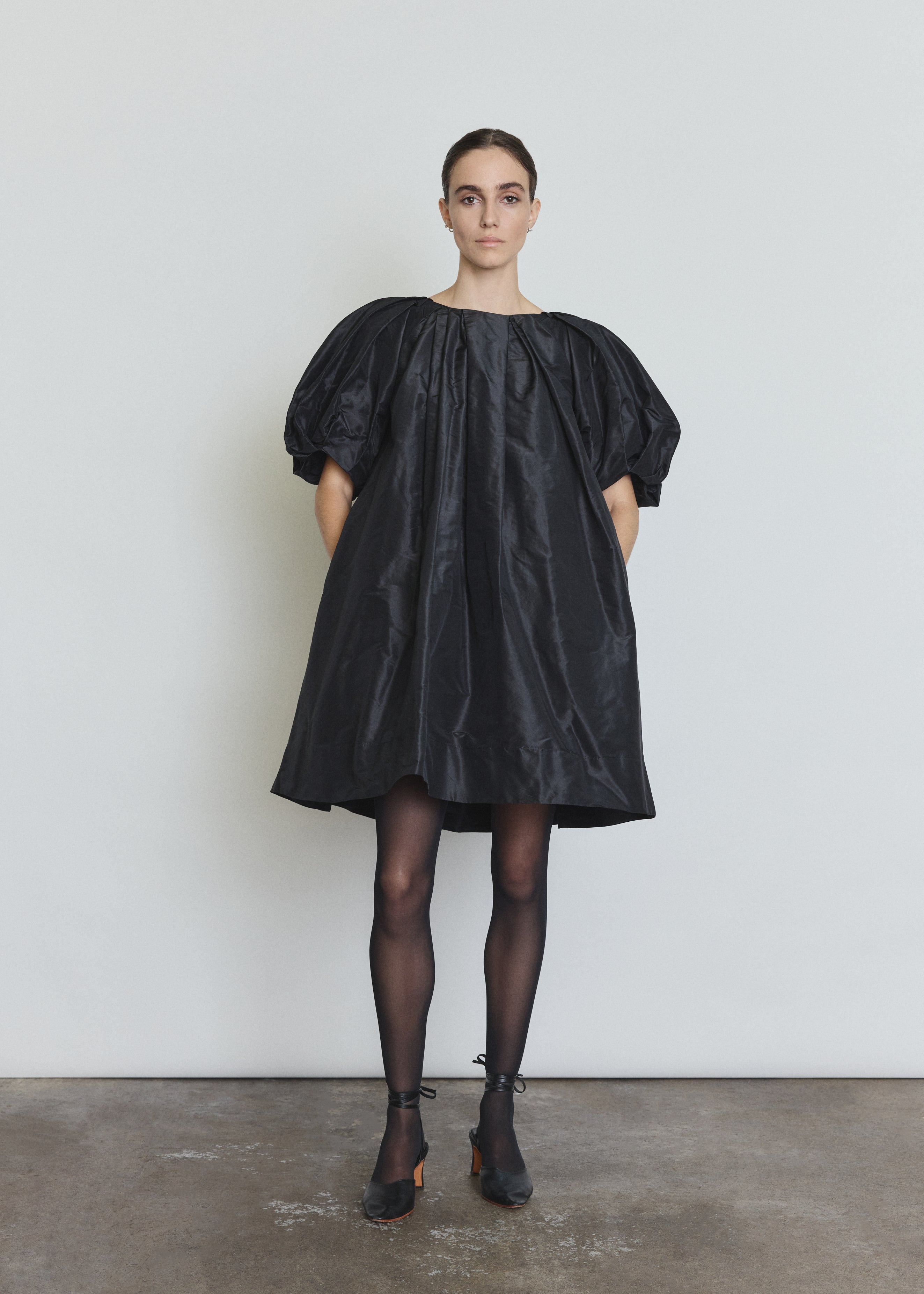 Side view of the black silk taffeta Kamperett Eva Dress showing the full A-line volume.