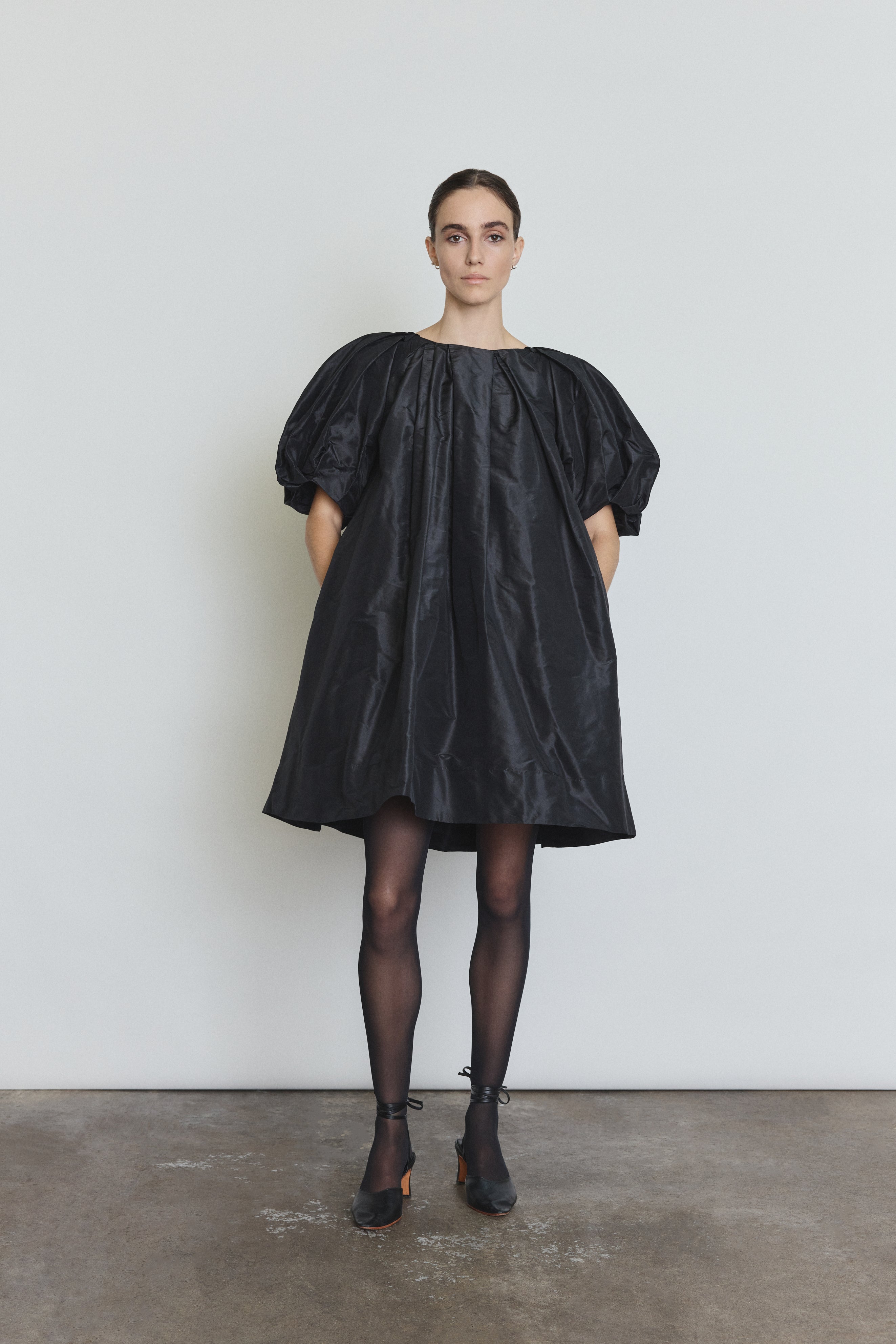 Side view of the black silk taffeta Kamperett Eva Dress showing the full A-line volume.