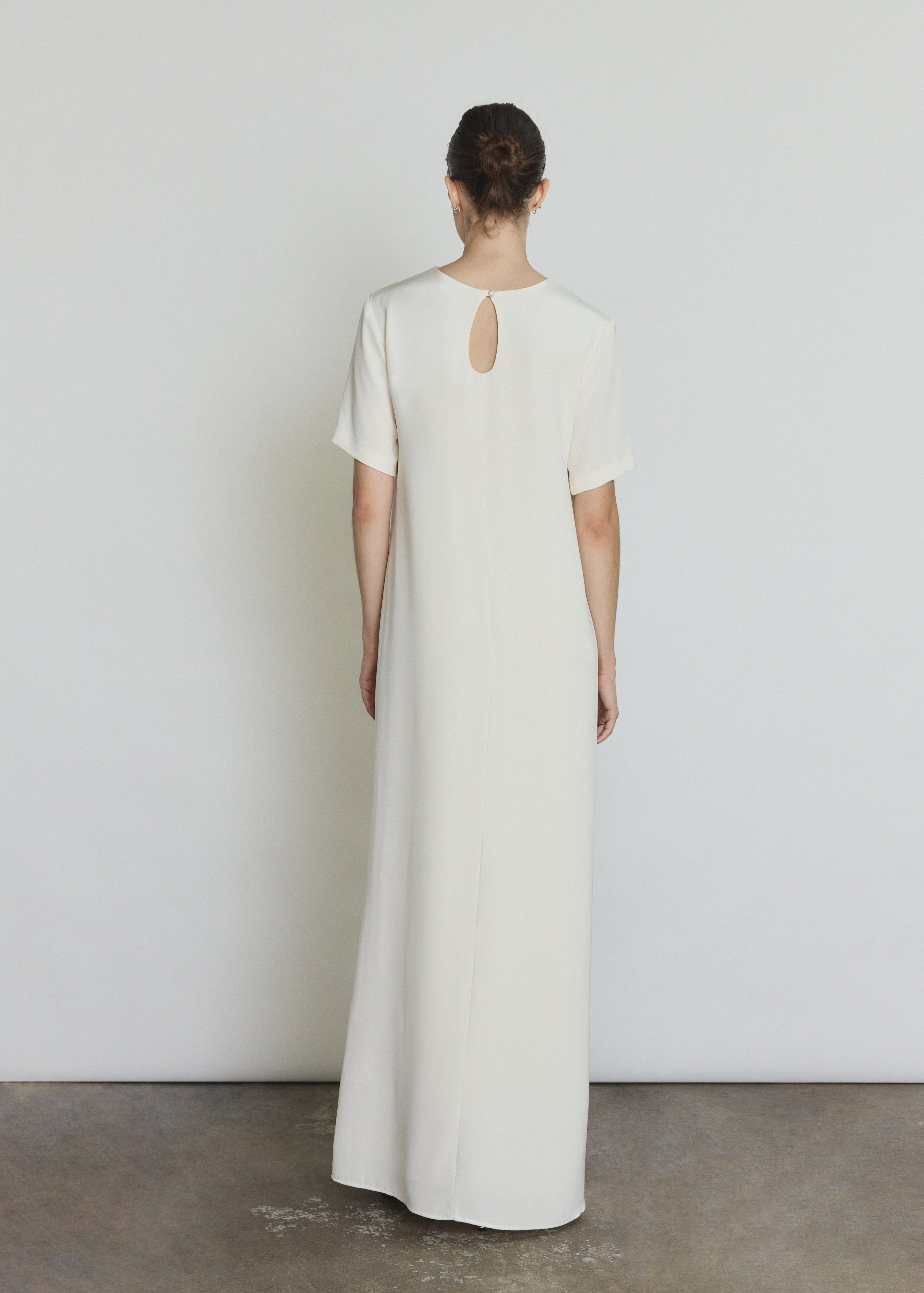 Back view of the alabaster silk crepe Kamperett Galerie Dress with single-button back closure.