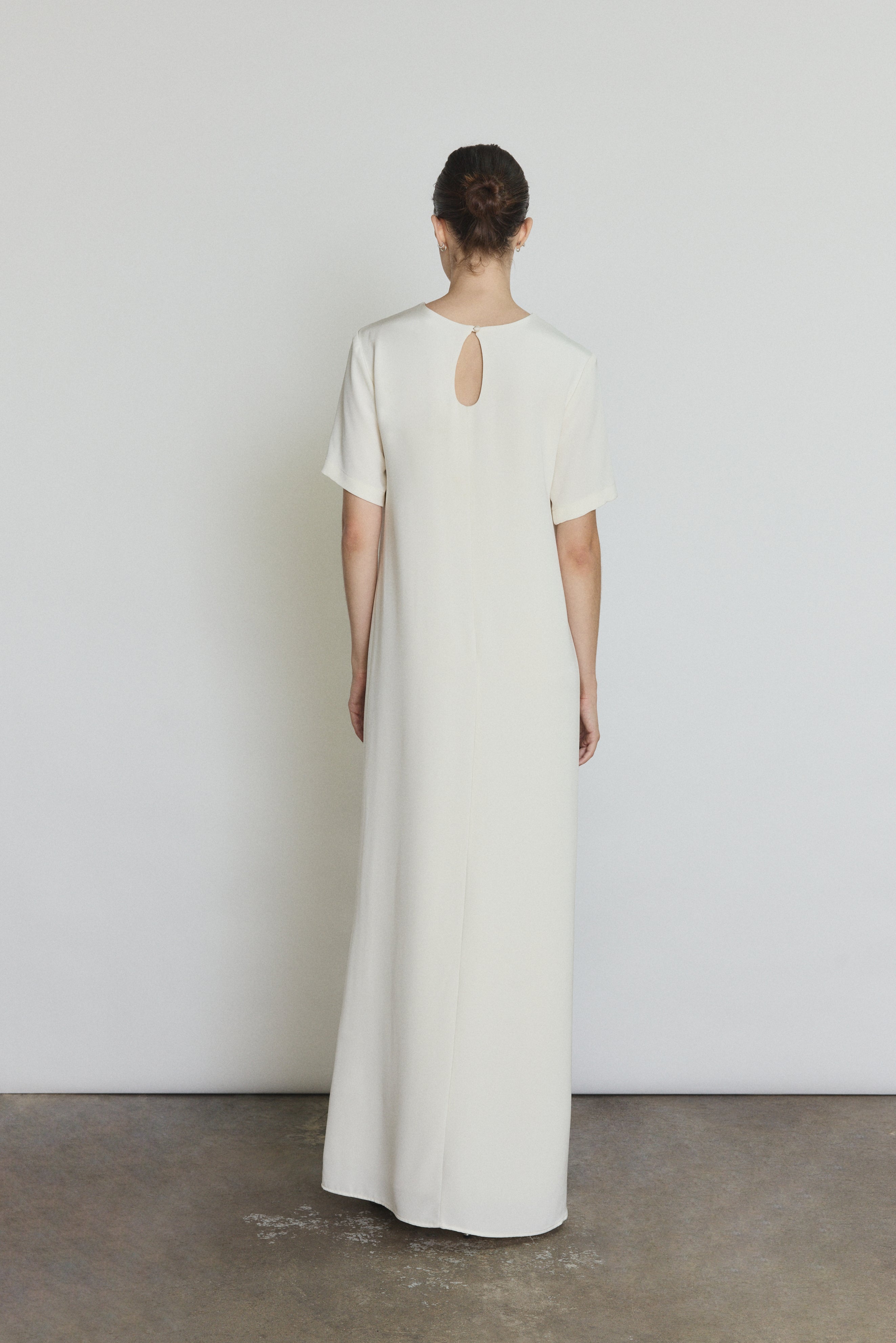 Back view of the alabaster silk crepe Kamperett Galerie Dress with single-button back closure.