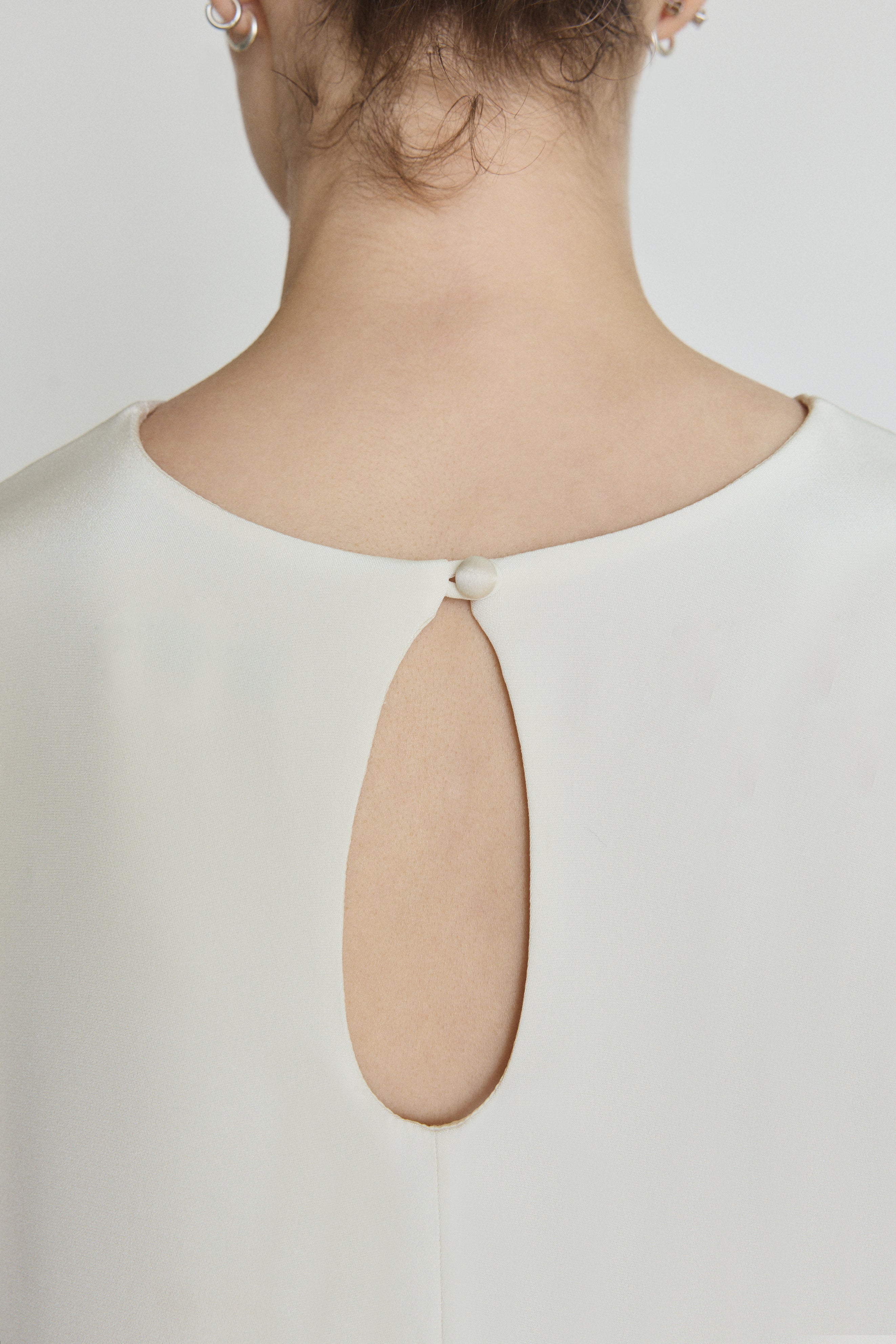 Detail of the alabaster silk crepe Kamperett Galerie Dress showing the fabric and neckline construction.