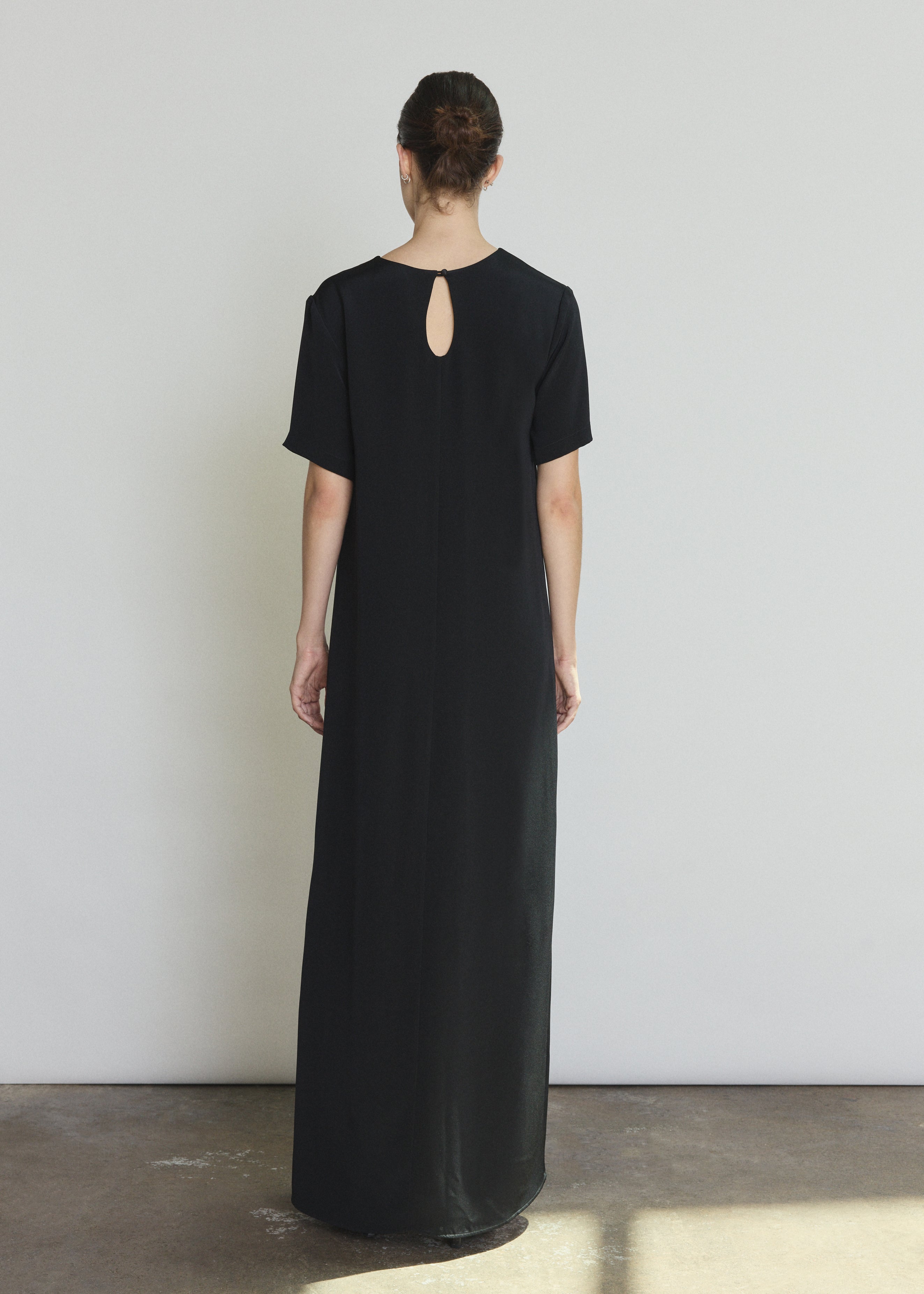 Back view of the black silk crepe Kamperett Galerie Dress with single-button back closure.
