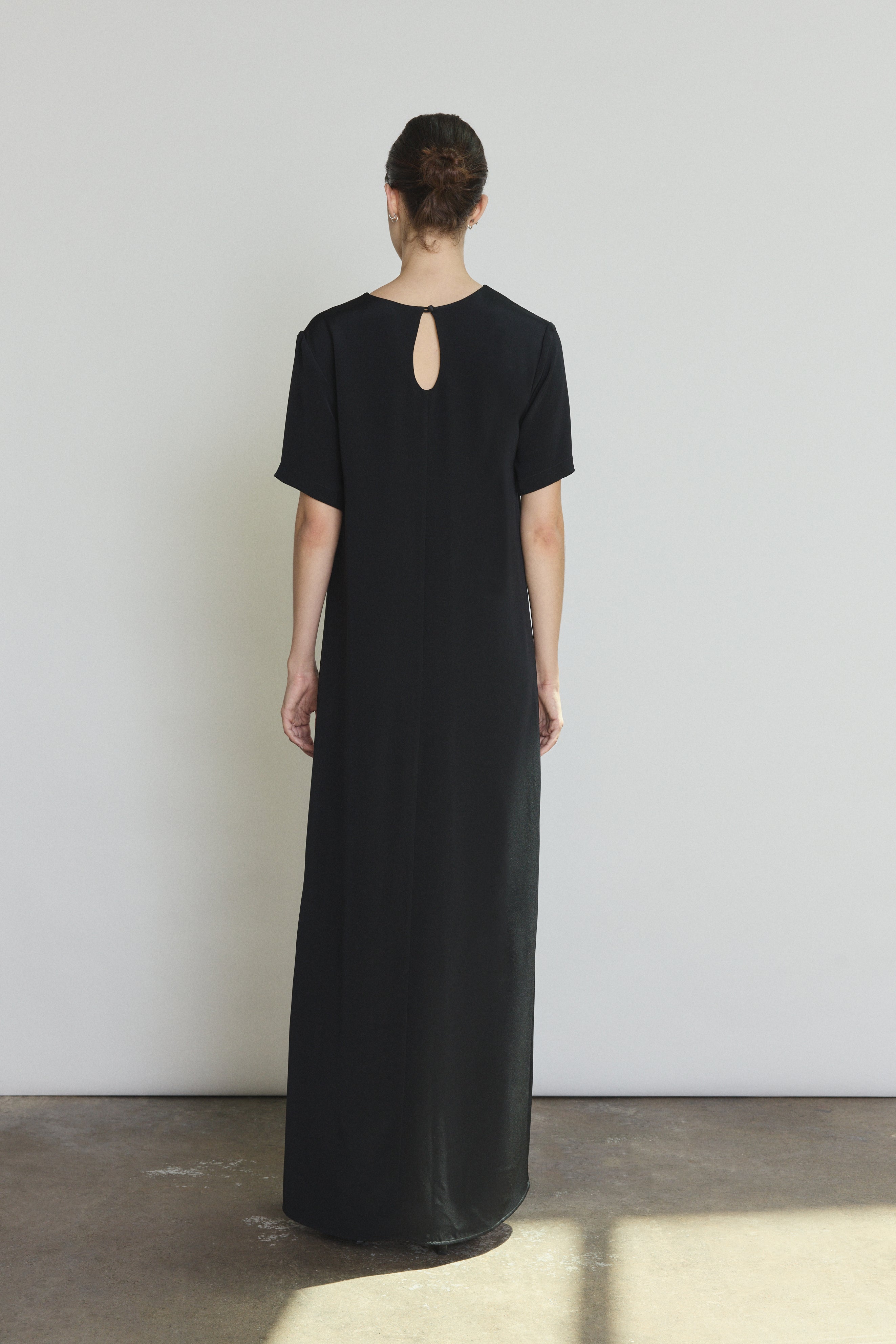 Back view of the black silk crepe Kamperett Galerie Dress with single-button back closure.
