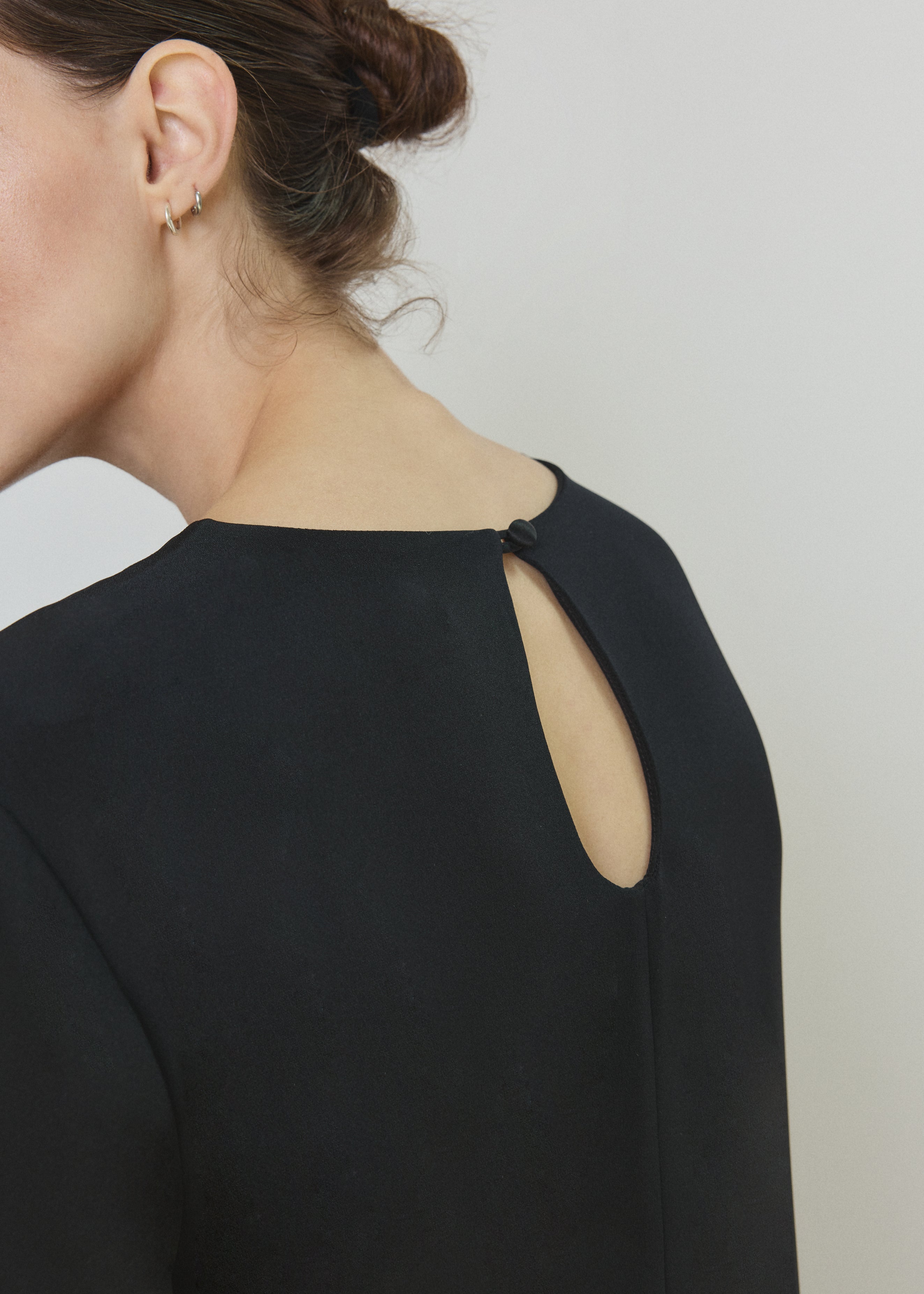Side view of the black silk crepe Kamperett Galerie Dress showing the softly defined column silhouette.