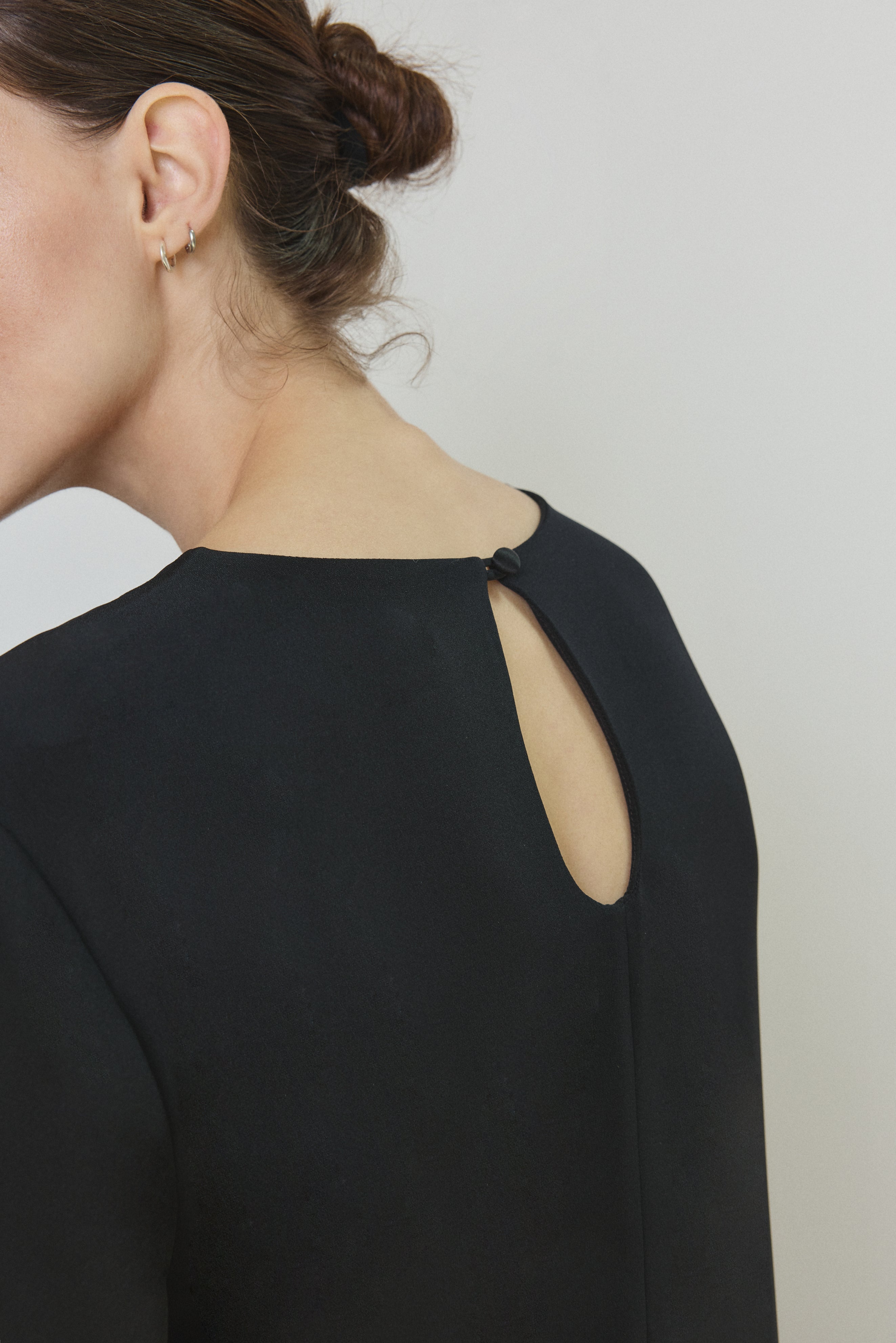 Side view of the black silk crepe Kamperett Galerie Dress showing the softly defined column silhouette.