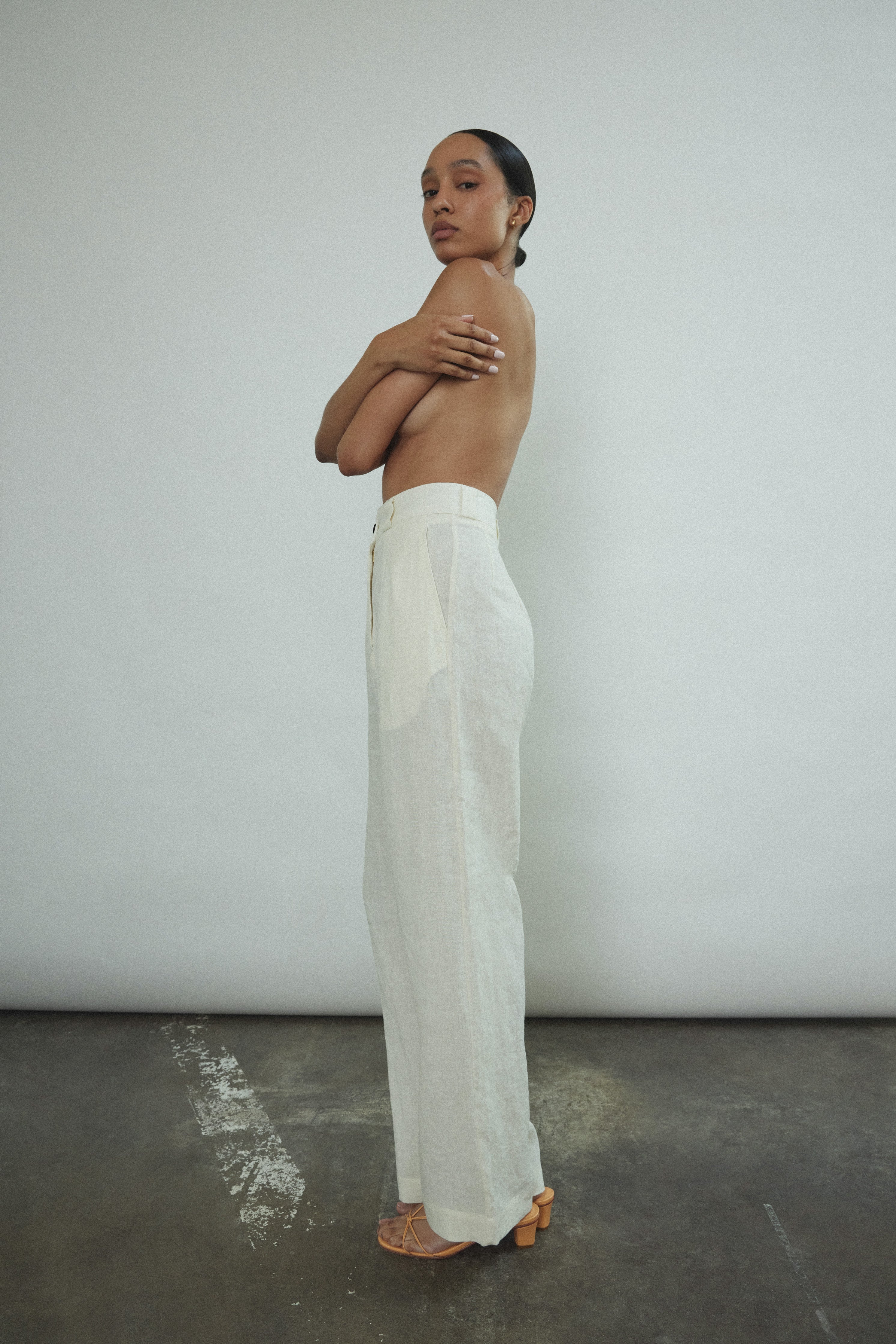 Angled view of the ivory Japanese linen Kamperett Huene Pant with fitted waistband and slant pockets.