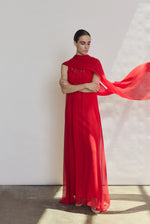 Editorial image of a model wearing the crimson Kamperett Iris Gown layered over the Caroline Slip Dress in Crimson.