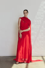 Front view of a model wearing the crimson silk chiffon Kamperett Iris Gown, a scarf-neck column gown with integrated capelet.