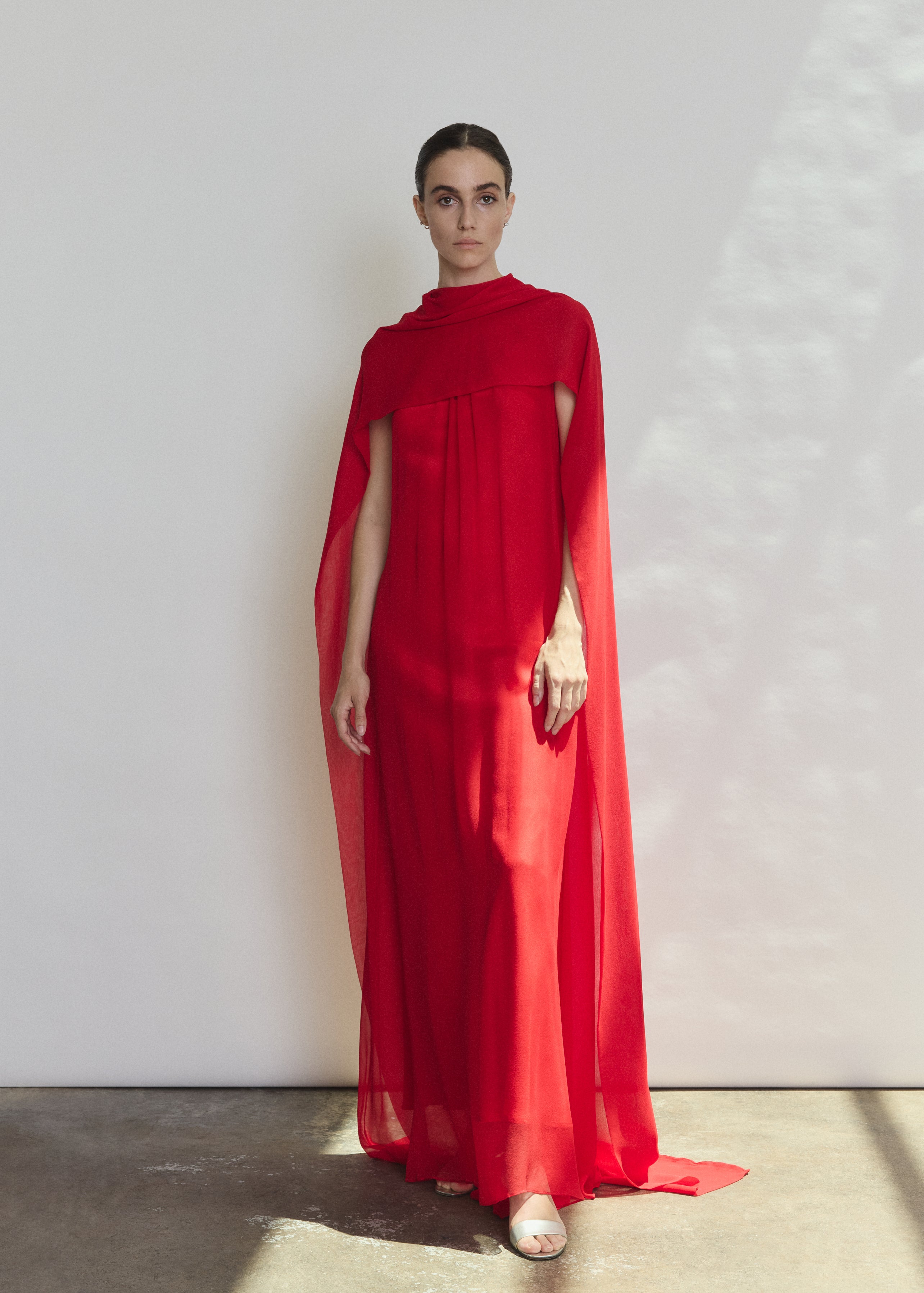 Side view of the crimson silk chiffon Kamperett Iris Gown showing the floating capelet.