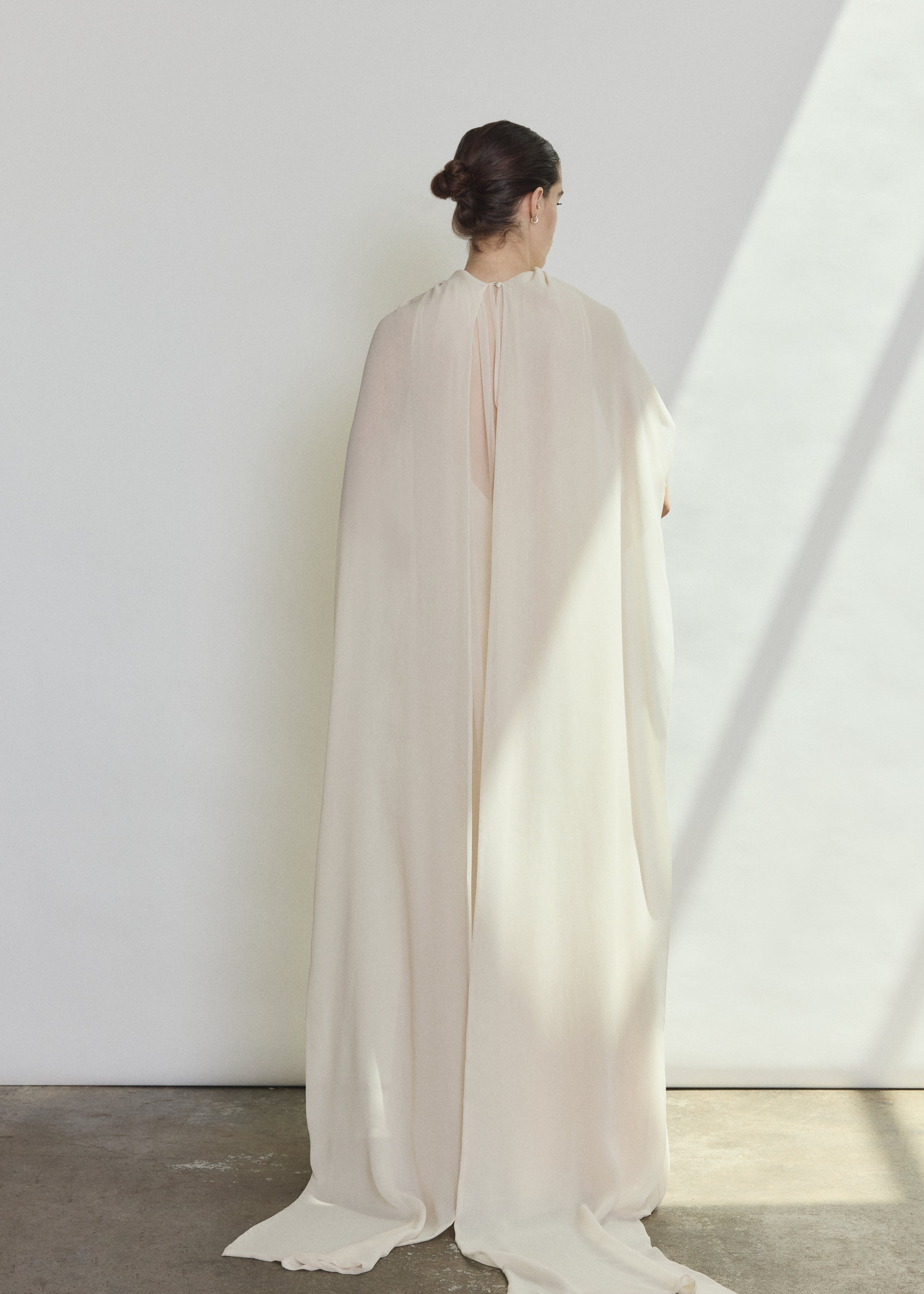 Editorial image of a bride wearing the ivory Kamperett Iris Gown layered over the Caroline Slip Dress in Ivory.