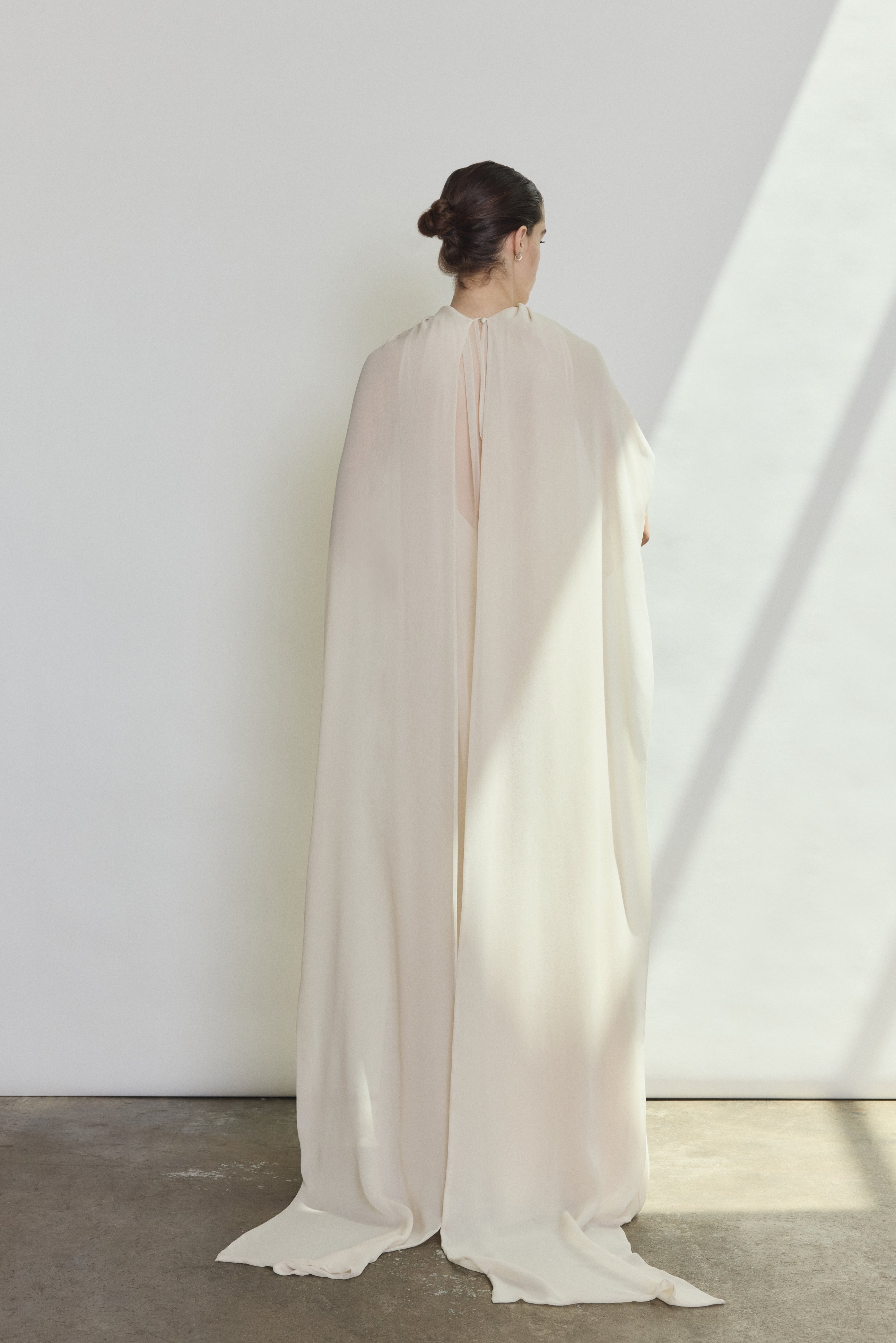 Editorial image of a bride wearing the ivory Kamperett Iris Gown layered over the Caroline Slip Dress in Ivory.