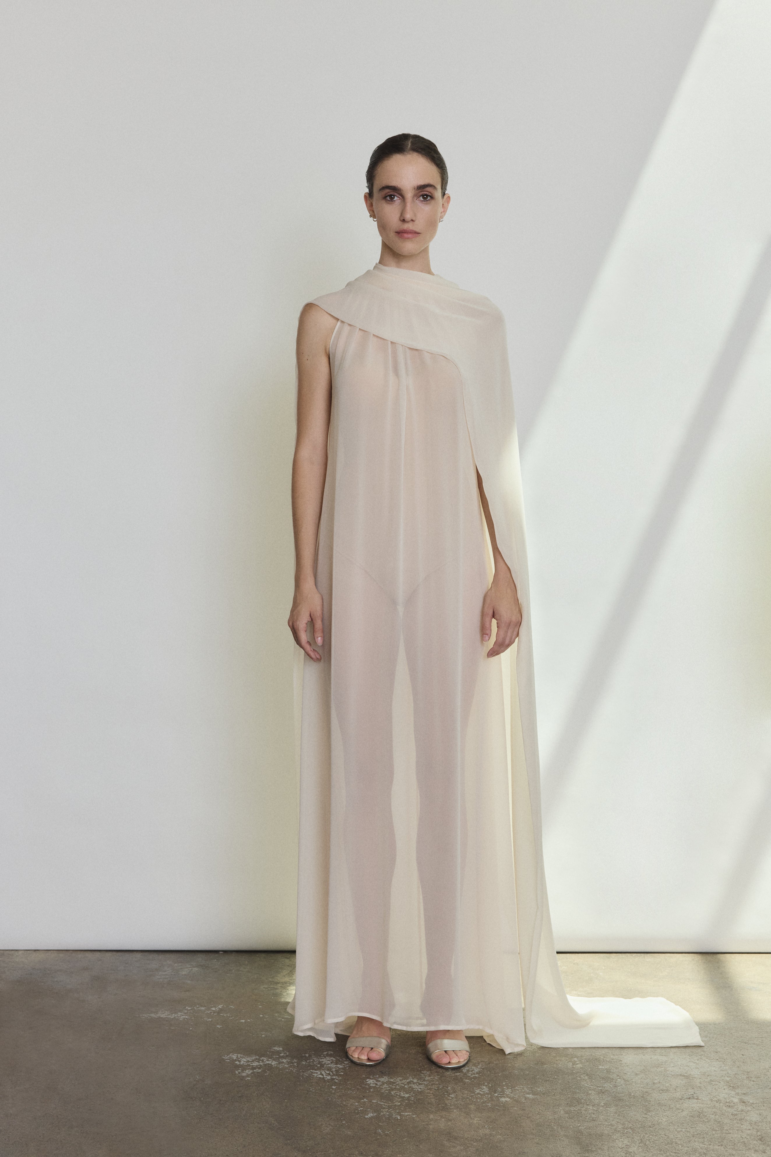 Editorial image of the ivory Kamperett Iris Gown with the capelet draped to reveal the shoulders.