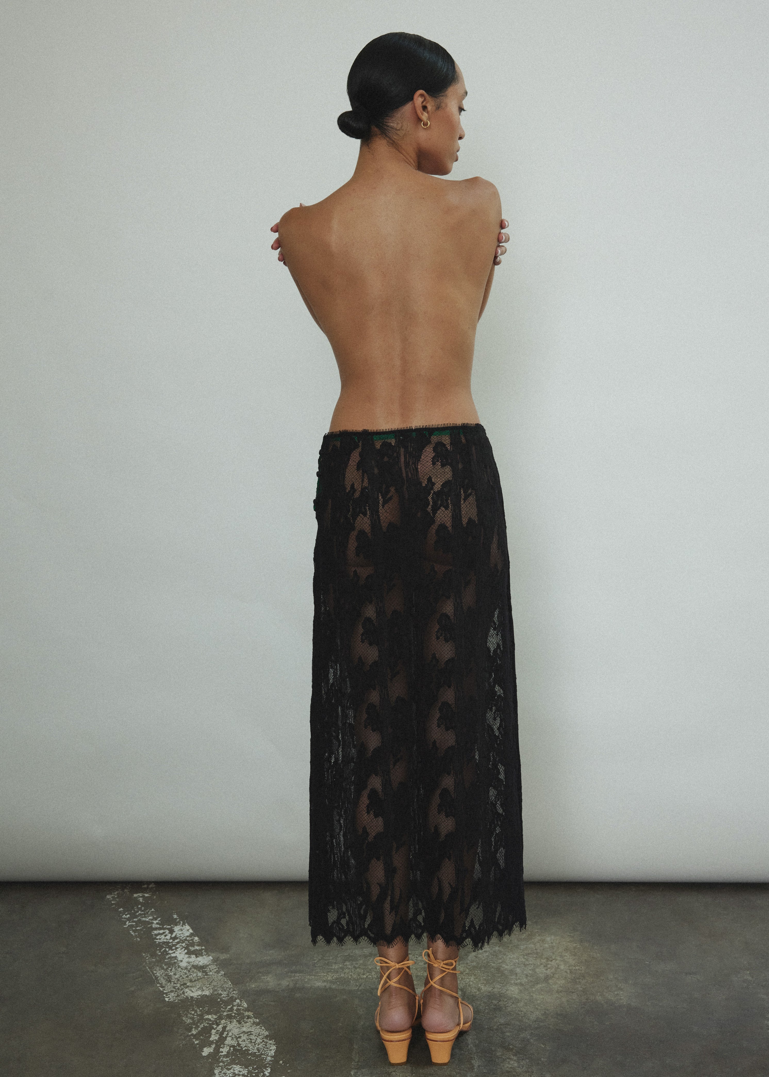 Back view of the black French lace Kamperett Isabella Skirt with fabric-covered button side closure.