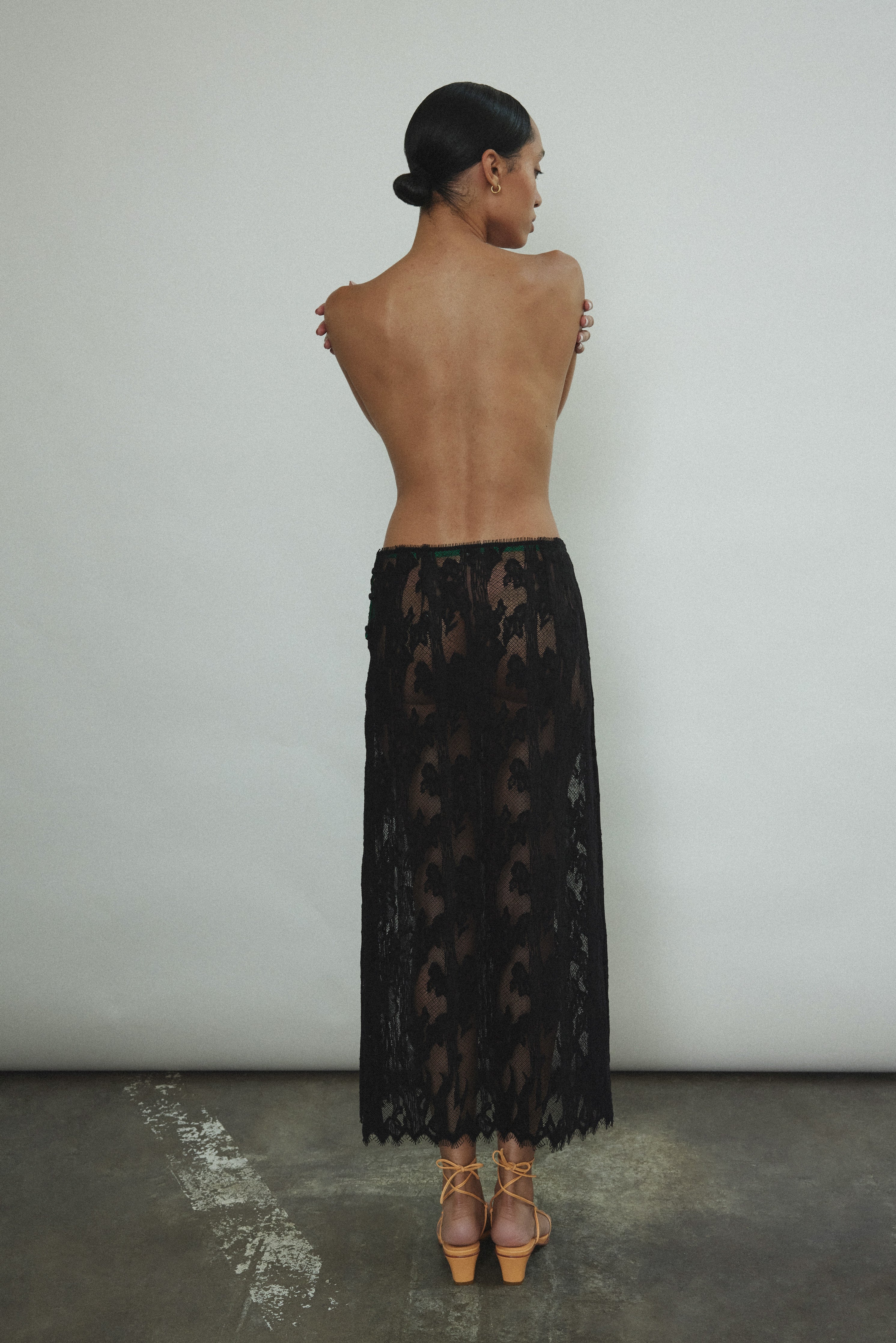 Back view of the black French lace Kamperett Isabella Skirt with fabric-covered button side closure.