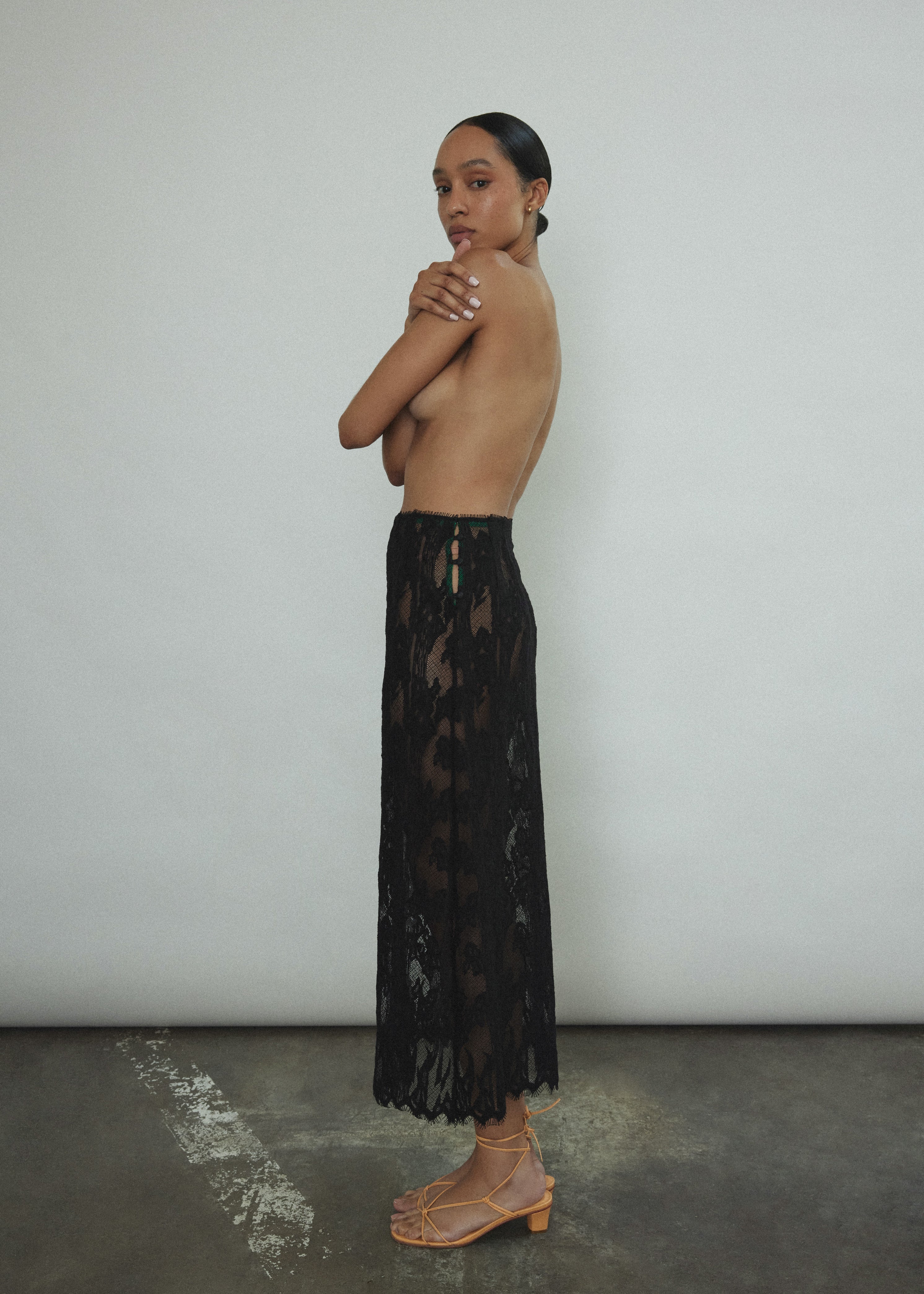 Side view of the black French lace Kamperett Isabella Skirt showing the straight-cut silhouette and eyelash lace hem.