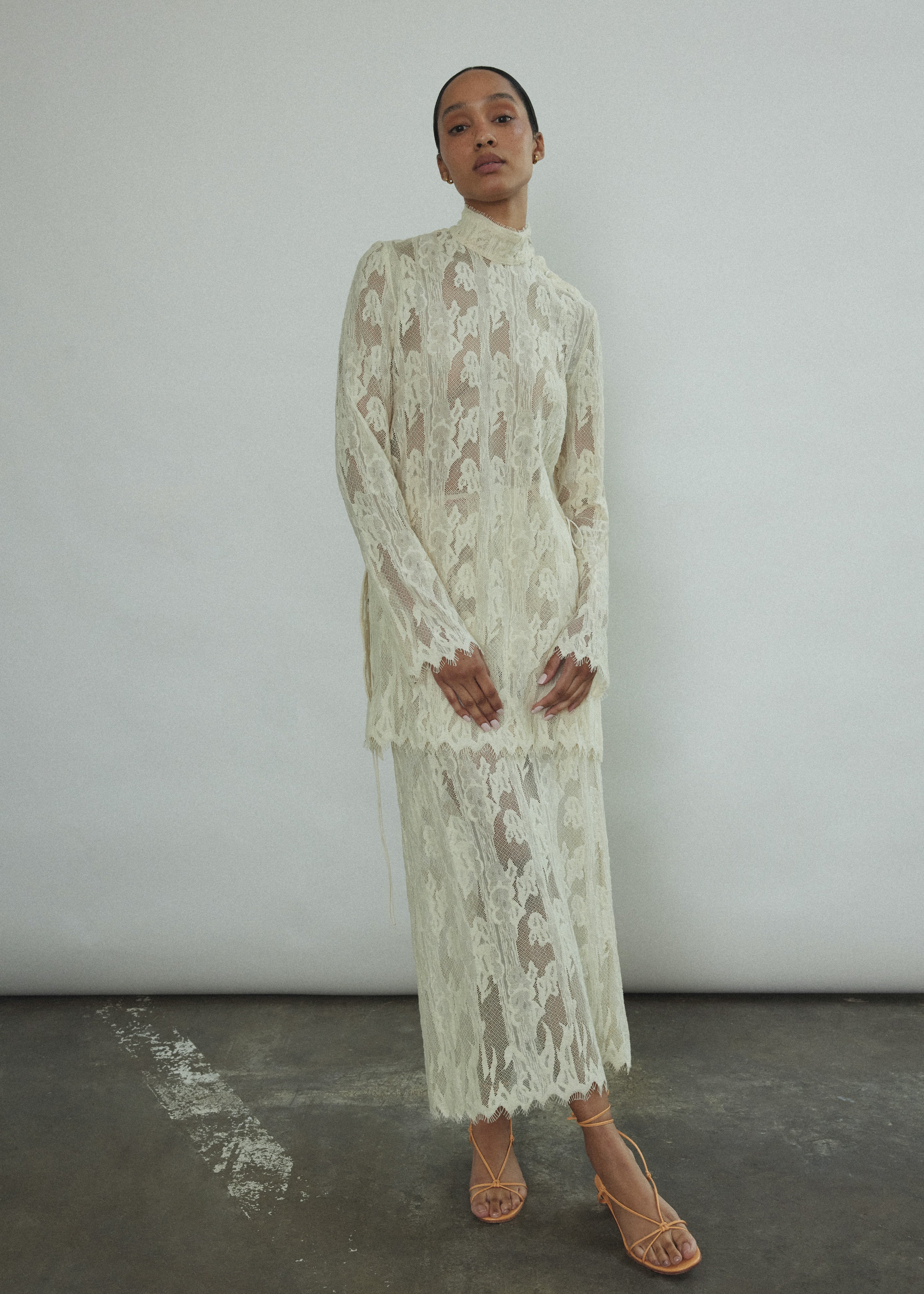 Side view of the cream French lace Kamperett Isabella Skirt, showing the straight-cut silhouette and eyelash lace hem.