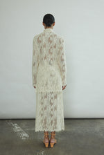 Close-up of the contrast binding and fabric-covered button closure at the waist of the cream French lace Isabella Skirt.