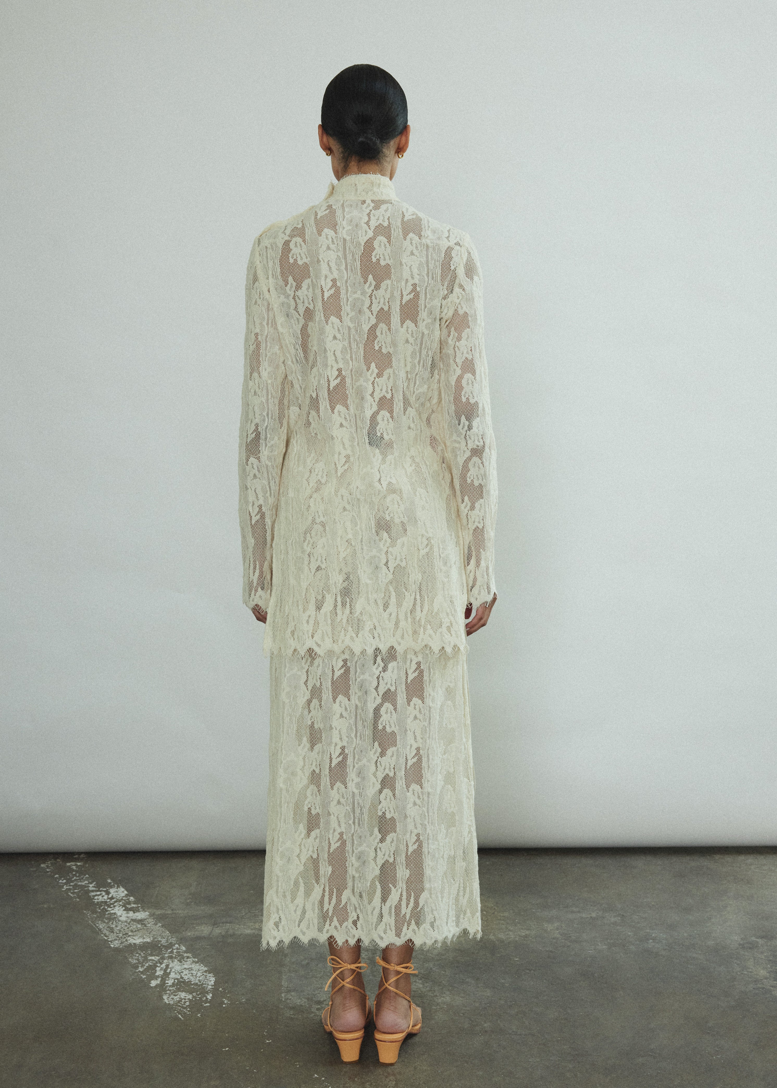 Close-up of the contrast binding and fabric-covered button closure at the waist of the cream French lace Isabella Skirt.