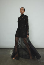 Kamperett Isabella Tunic in black lace mid-movement, silk cord ties flowing at sides, eyelash hem lifting softly, capturing the fluid drape of unlined French lace fabric.