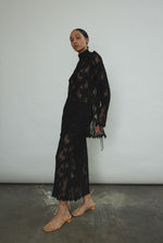 Kamperett Isabella Tunic in black French lace, full-length side view showing straight-cut silhouette, mock neck, eyelash lace hem, and long sleeves with wrist zipper closure.