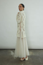 Kamperett Isabella Tunic in cream French lace, full-length side view showing straight-cut silhouette, mock neck, eyelash lace hem, and long sleeves with wrist zipper closure.