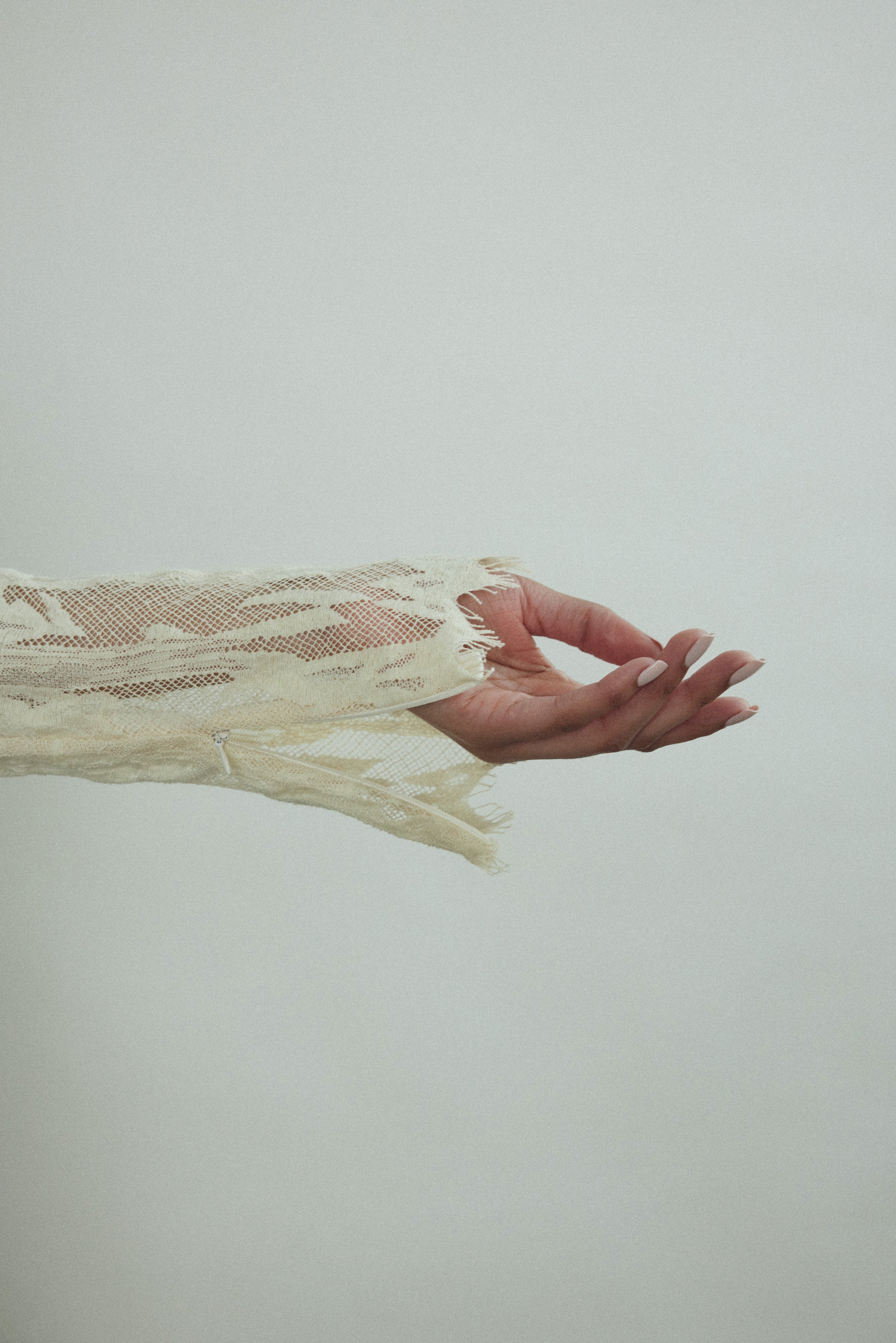 Kamperett Isabella Tunic in cream French lace, editorial close-up of wrist zippers.