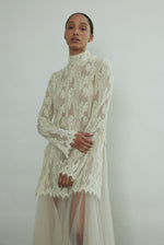Cream French lace tunic, straight-cut silhouette, mock neck, long sleeves with eyelash lace hem. Minimalist occasionwear made in California.
