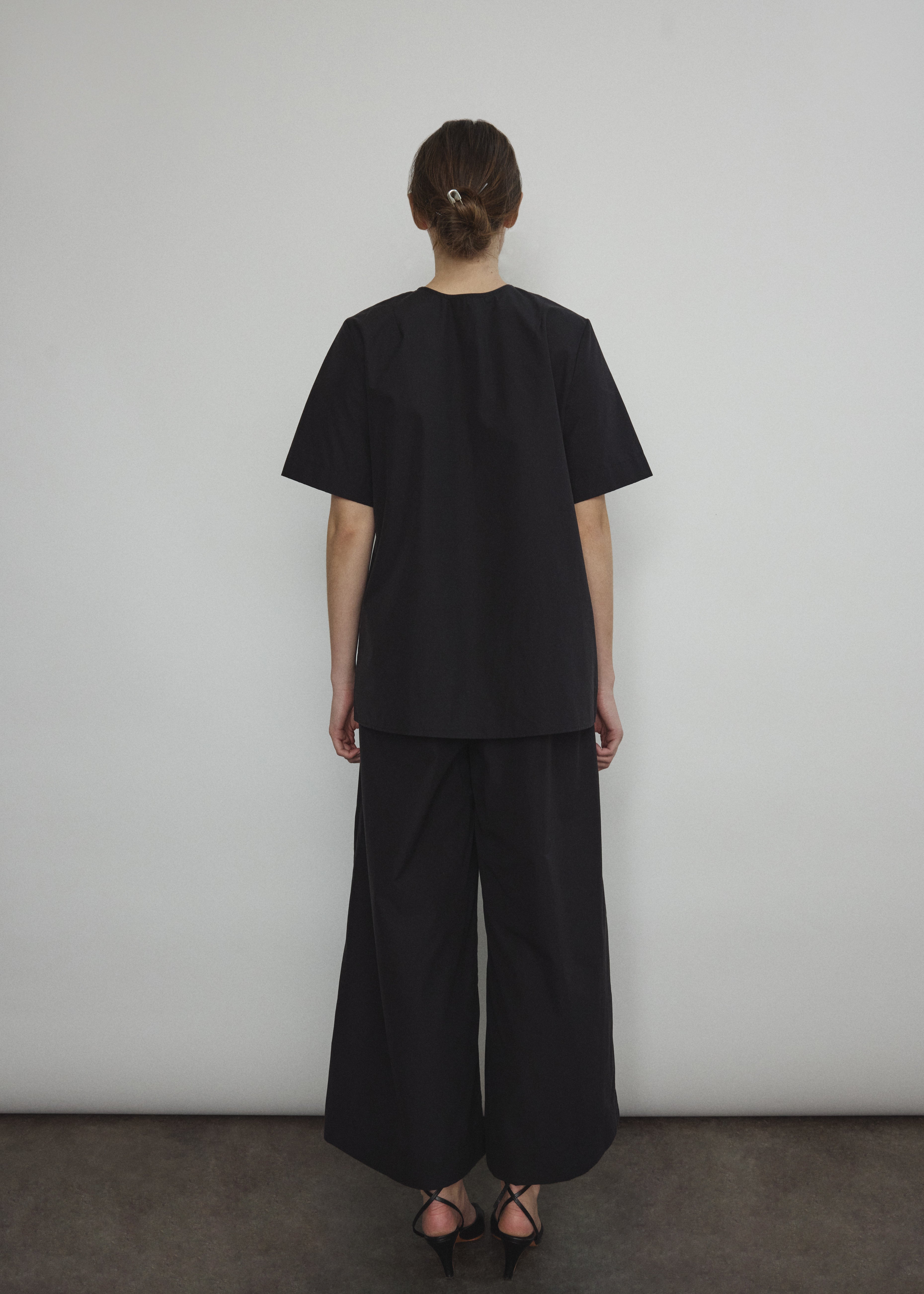 Back view of the black Japanese cotton lawn Kamperett Jette Tee showing the reversible construction with shoulder darts.