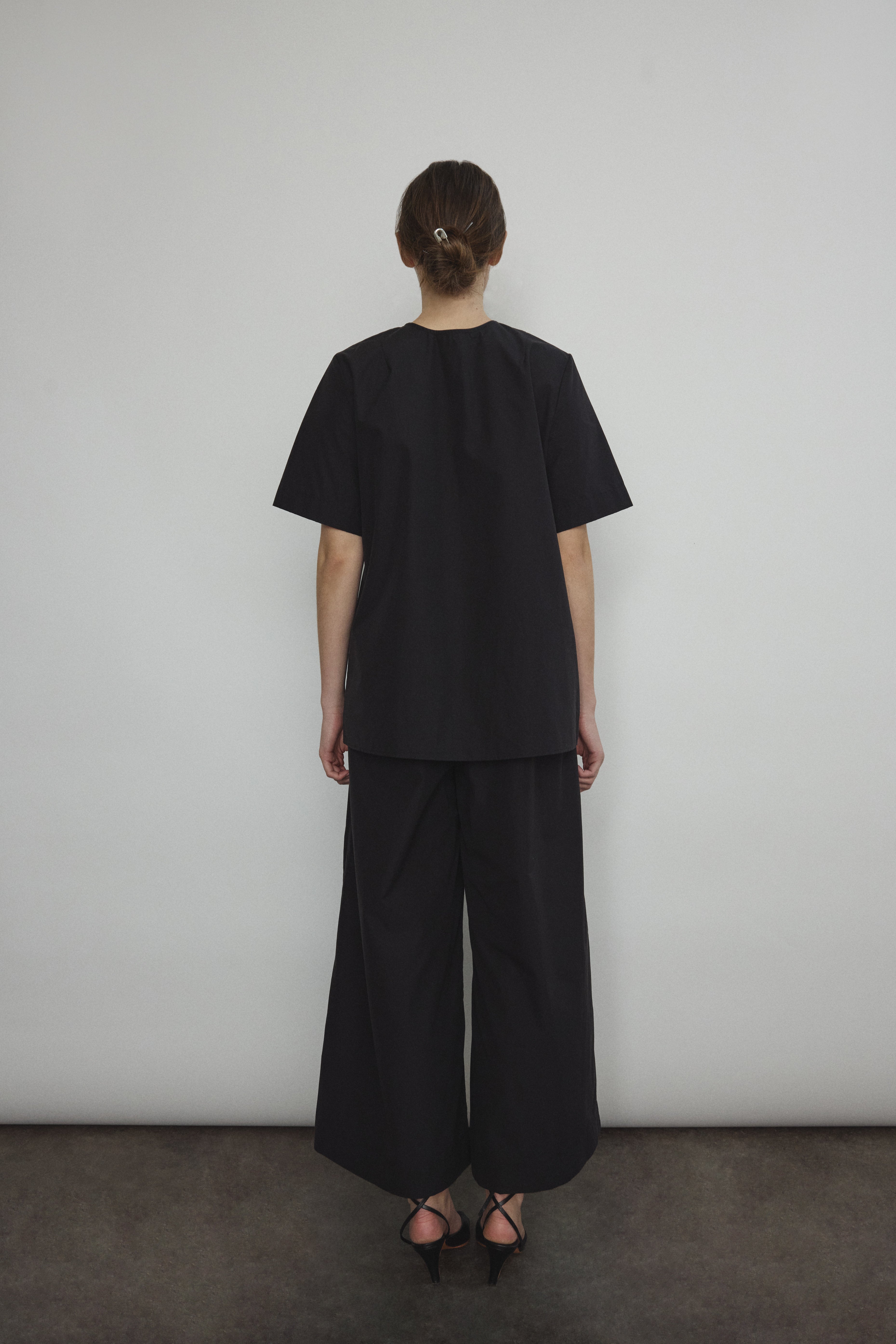 Back view of the black Japanese cotton lawn Kamperett Jette Tee showing the reversible construction with shoulder darts.