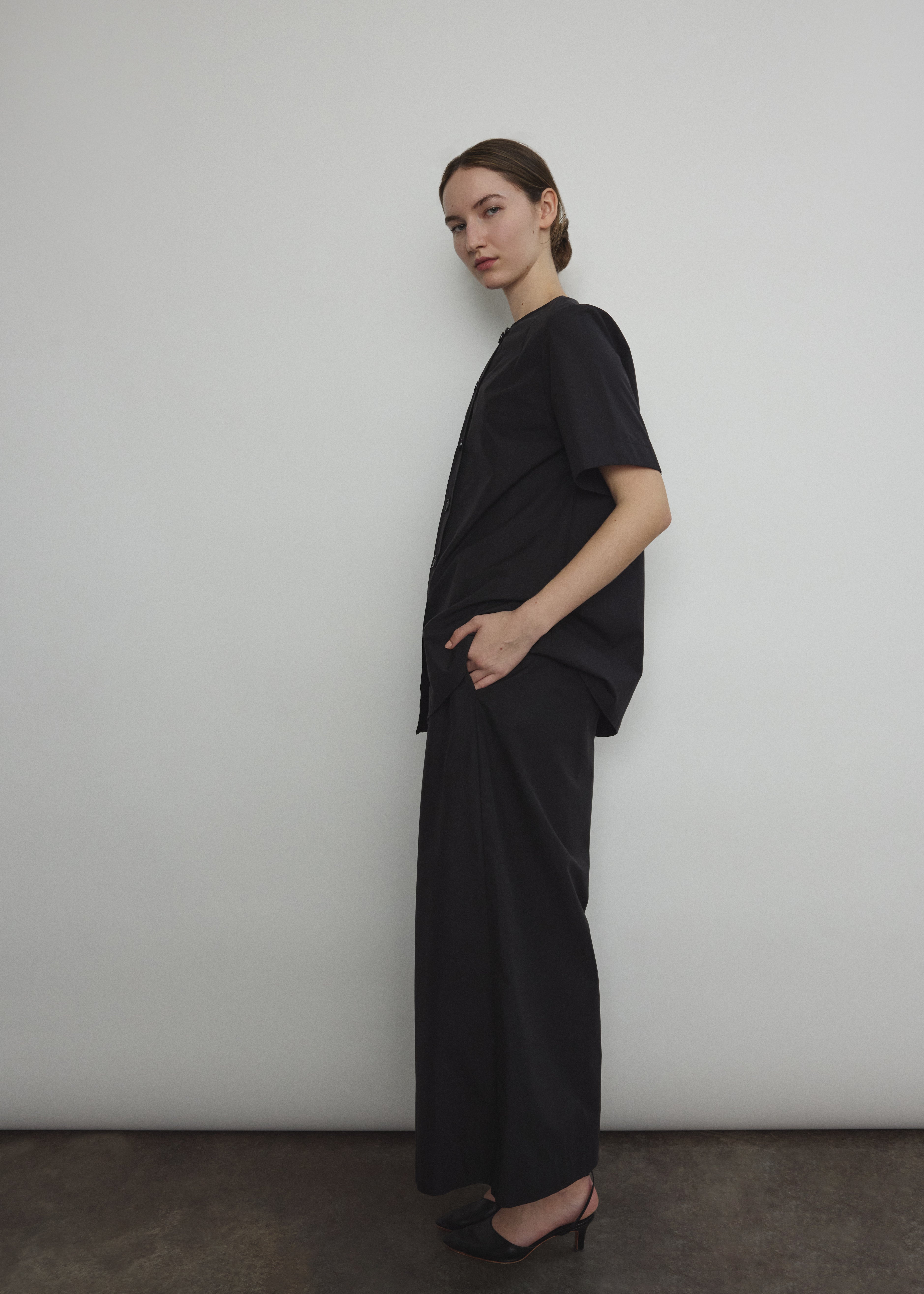 Side view of the black Japanese cotton lawn Kamperett Jette Tee with oversized cut.