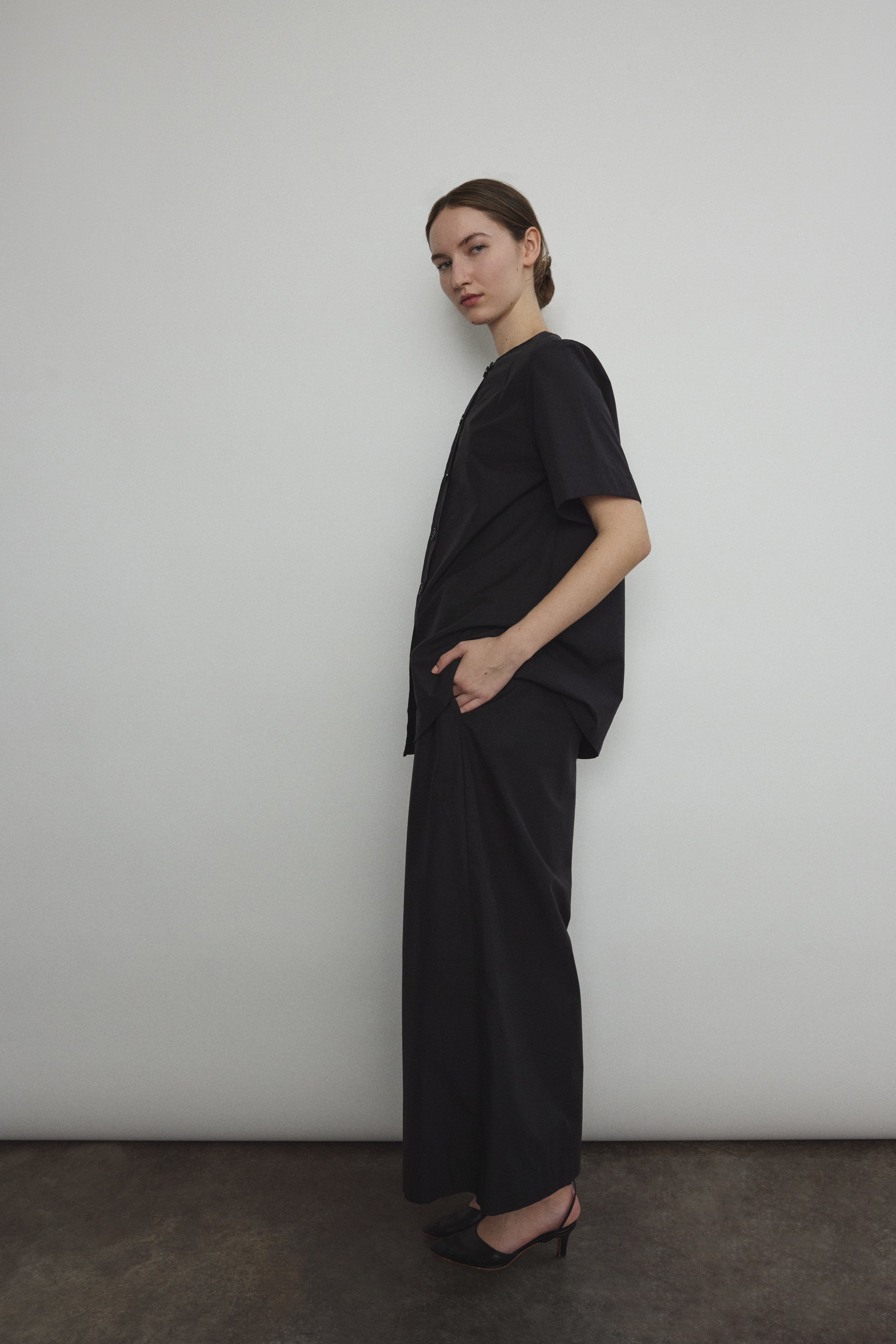 Side view of the black Japanese cotton lawn Kamperett Jette Tee with oversized cut.