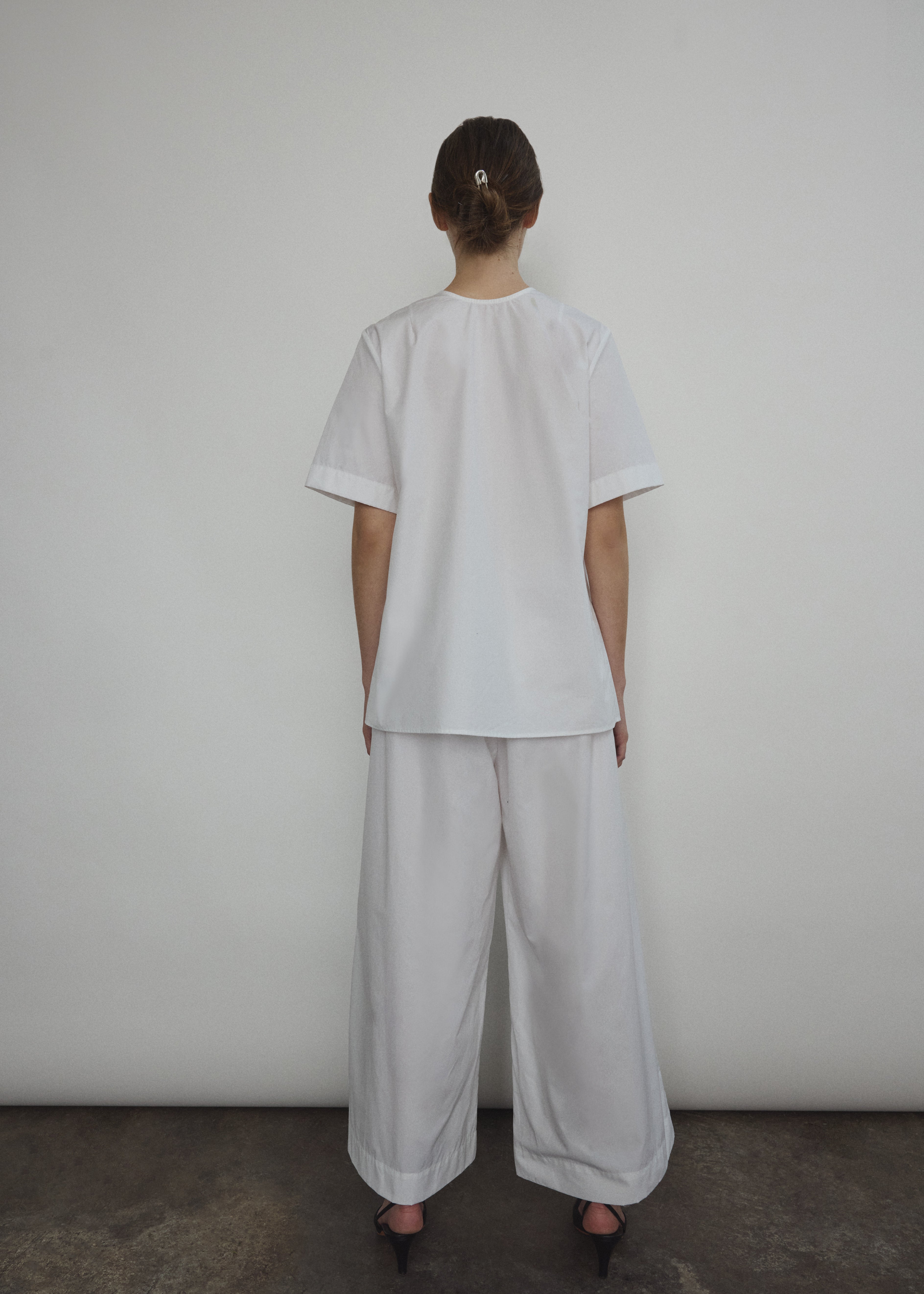 The white Kamperett Jette Cotton Tee styled with the Alix Pant for a modern minimalist look.