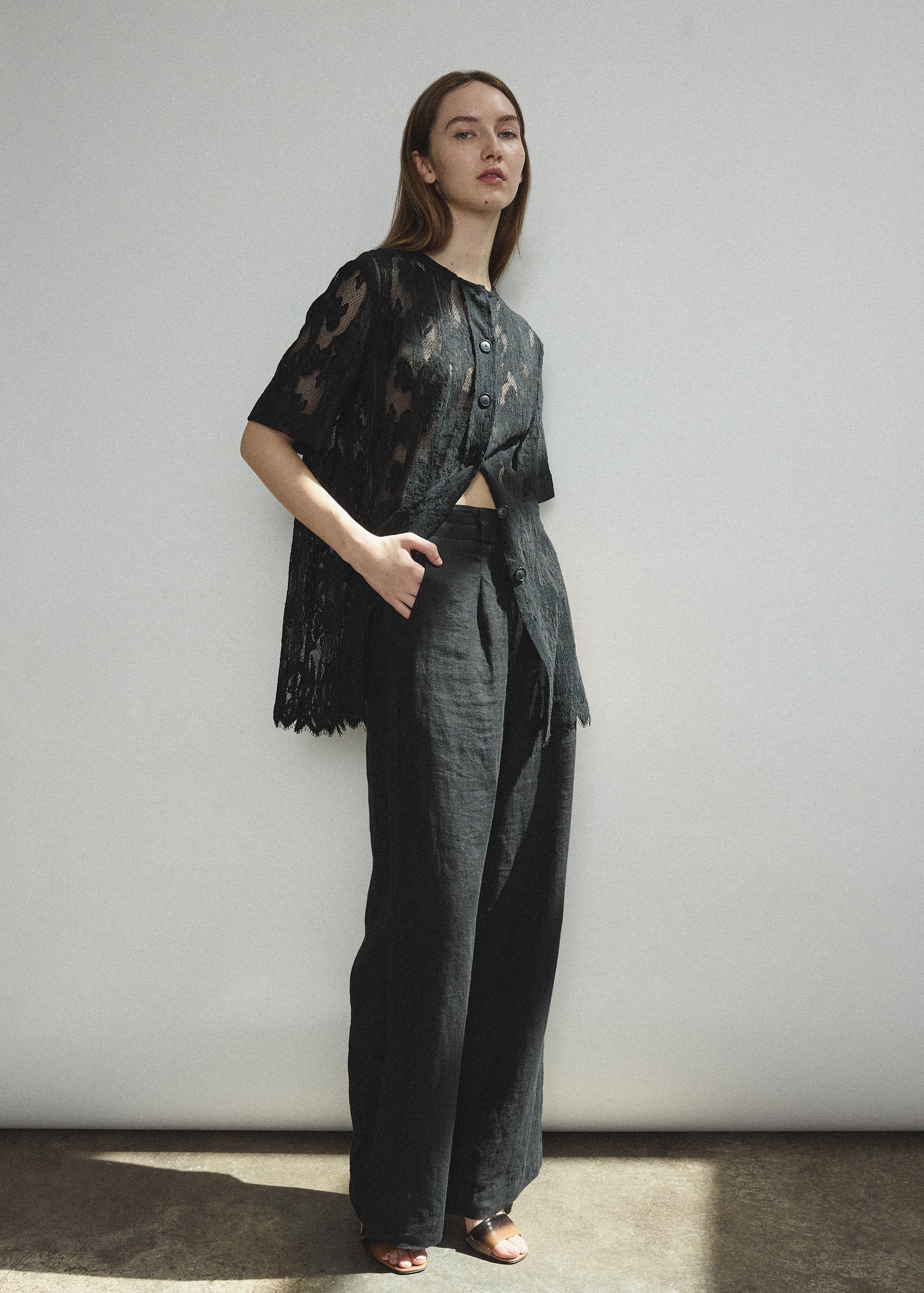 Angled view of the black French lace Kamperett Jette Tee with oversized reversible cut.