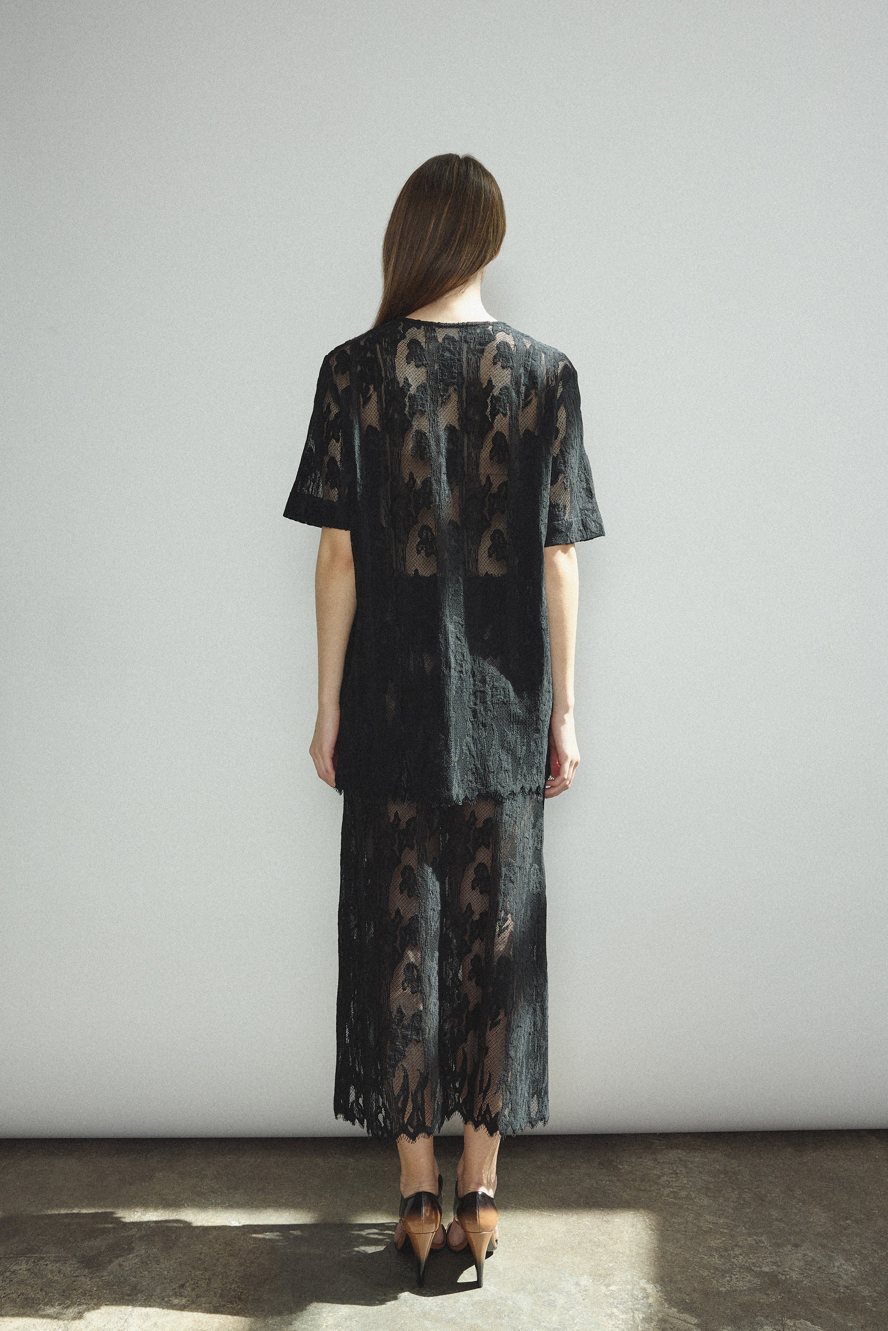Back view of the black French lace Kamperett Jette Tee showing the reversible construction with shoulder darts.