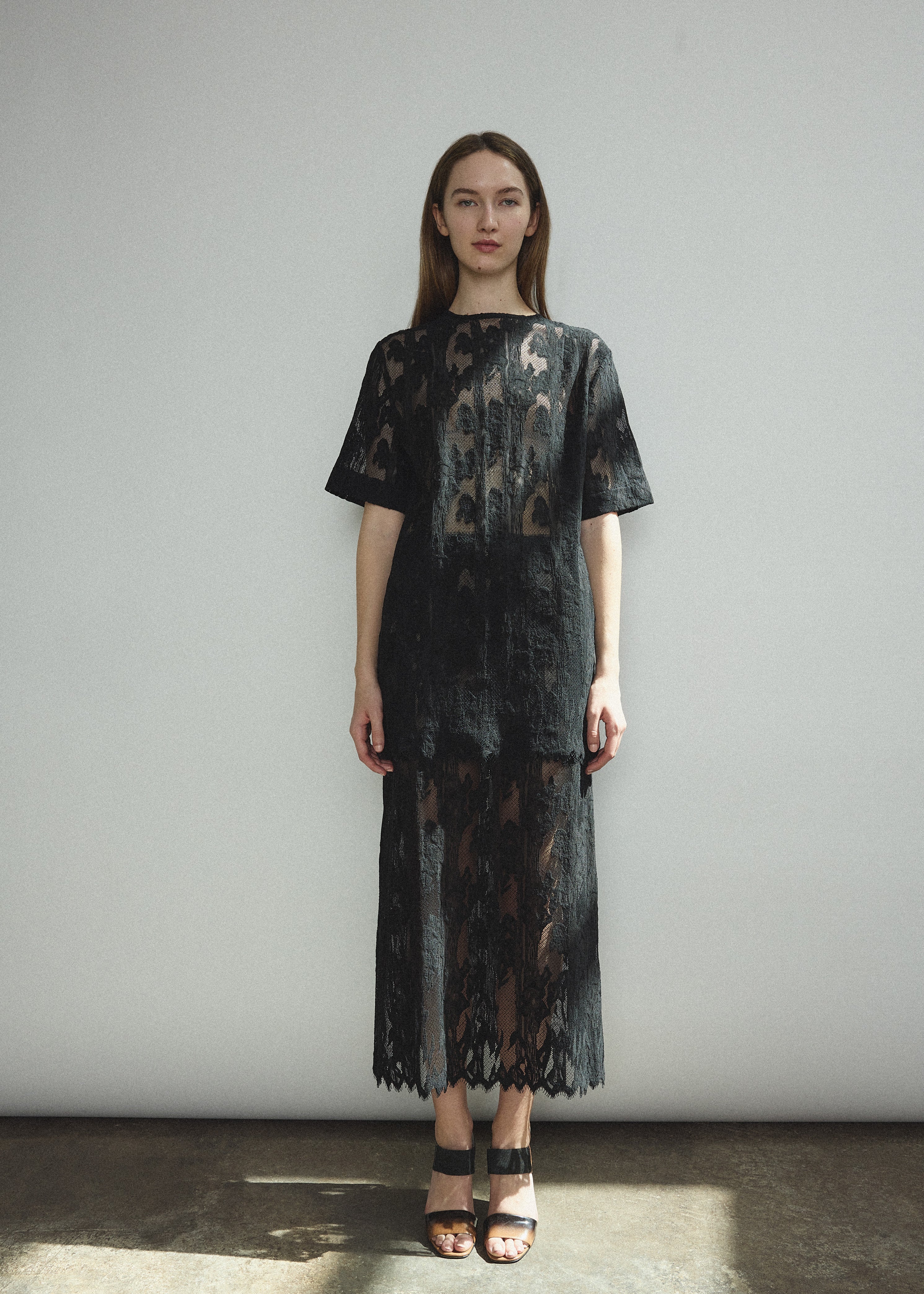Front view of a model wearing the black French lace Kamperett Jette Tee with wide button placket and shoulder darts.