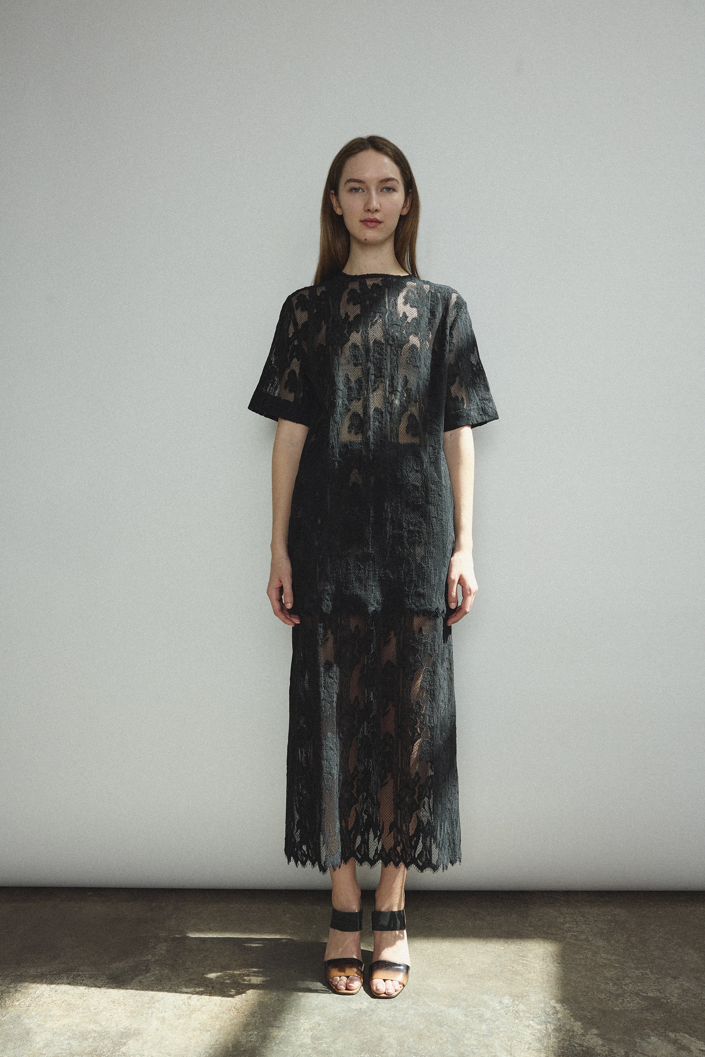 Front view of a model wearing the black French lace Kamperett Jette Tee with wide button placket and shoulder darts.