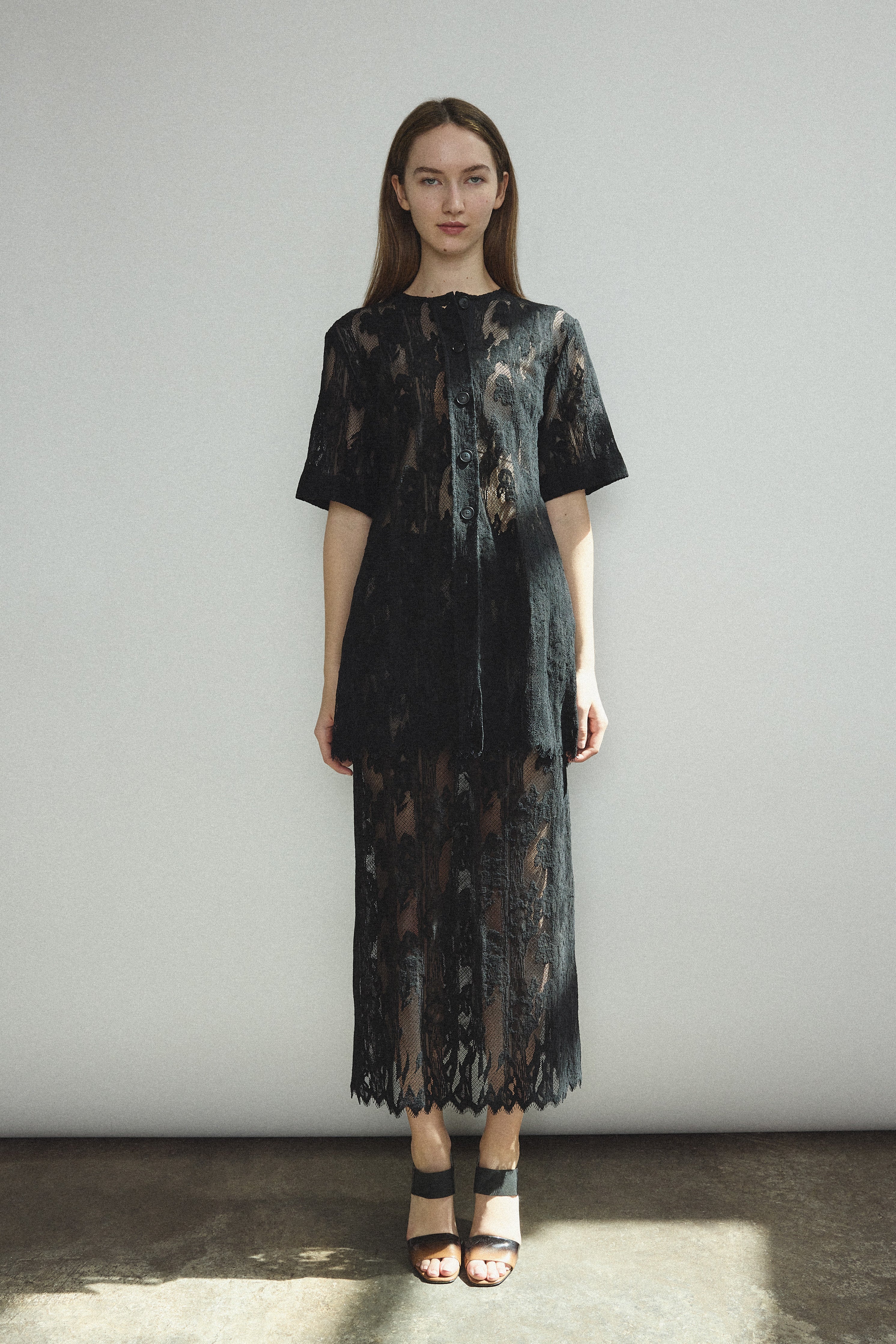 Side view of the black French lace Kamperett Jette Tee styled with the Huene Pant.