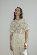 Editorial image of a model in the cream French lace Kamperett Jette Tee.