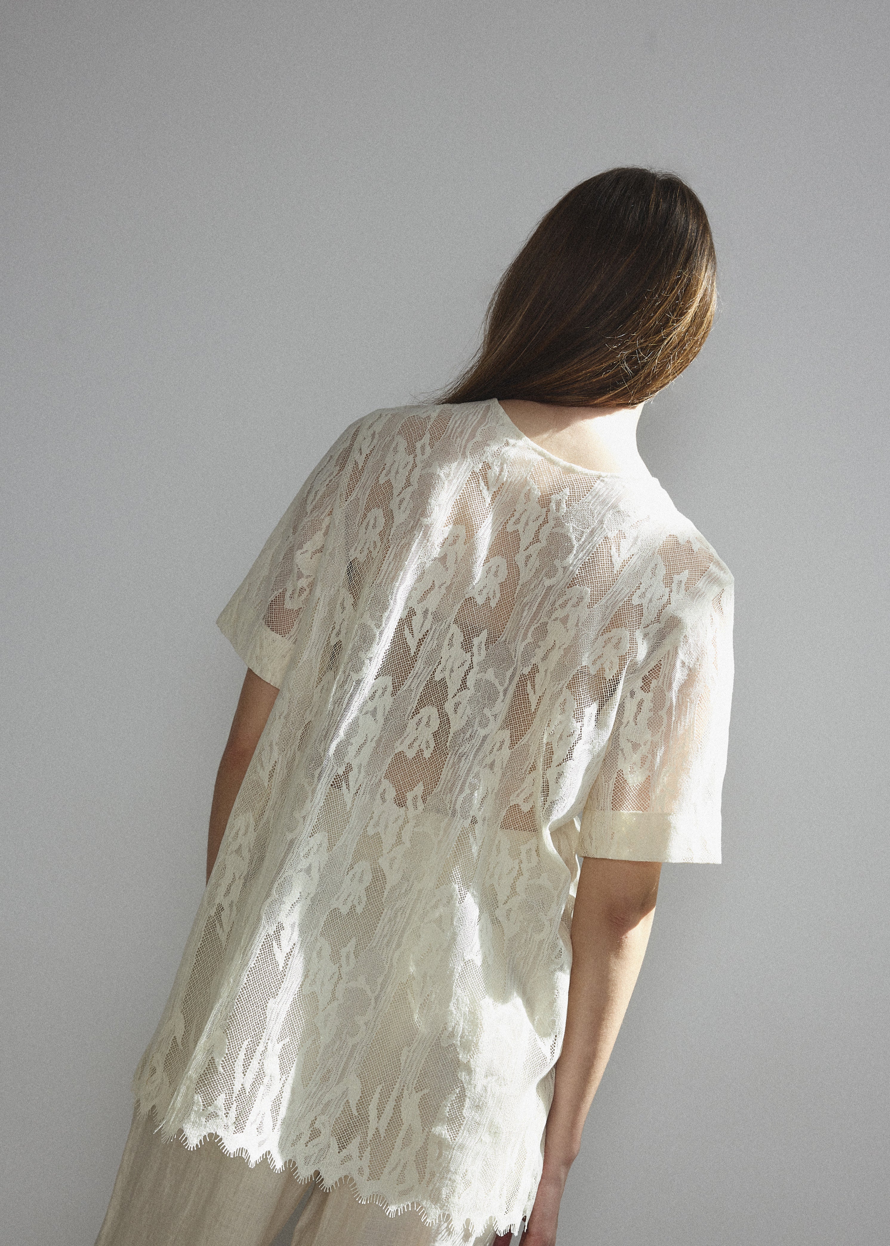Detail of the wide button placket on the cream French lace Kamperett Jette Tee.