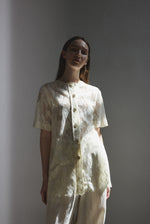 Side view of the cream French lace Kamperett Jette Tee with oversized reversible cut.