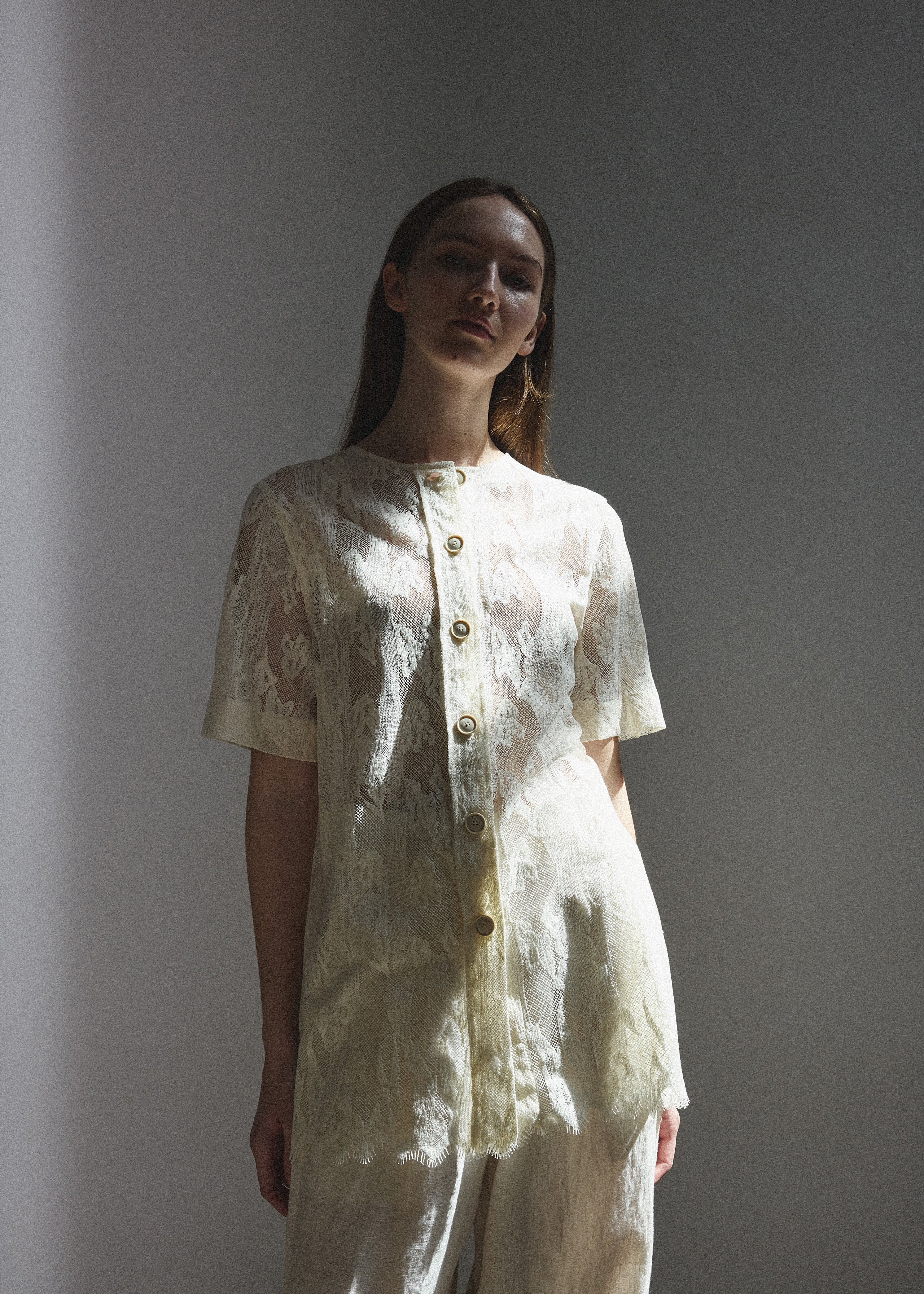 Side view of the cream French lace Kamperett Jette Tee with oversized reversible cut.