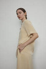 Back view of the beige silk crepe Kamperett Jette Tee showing the reversible shoulder darts.