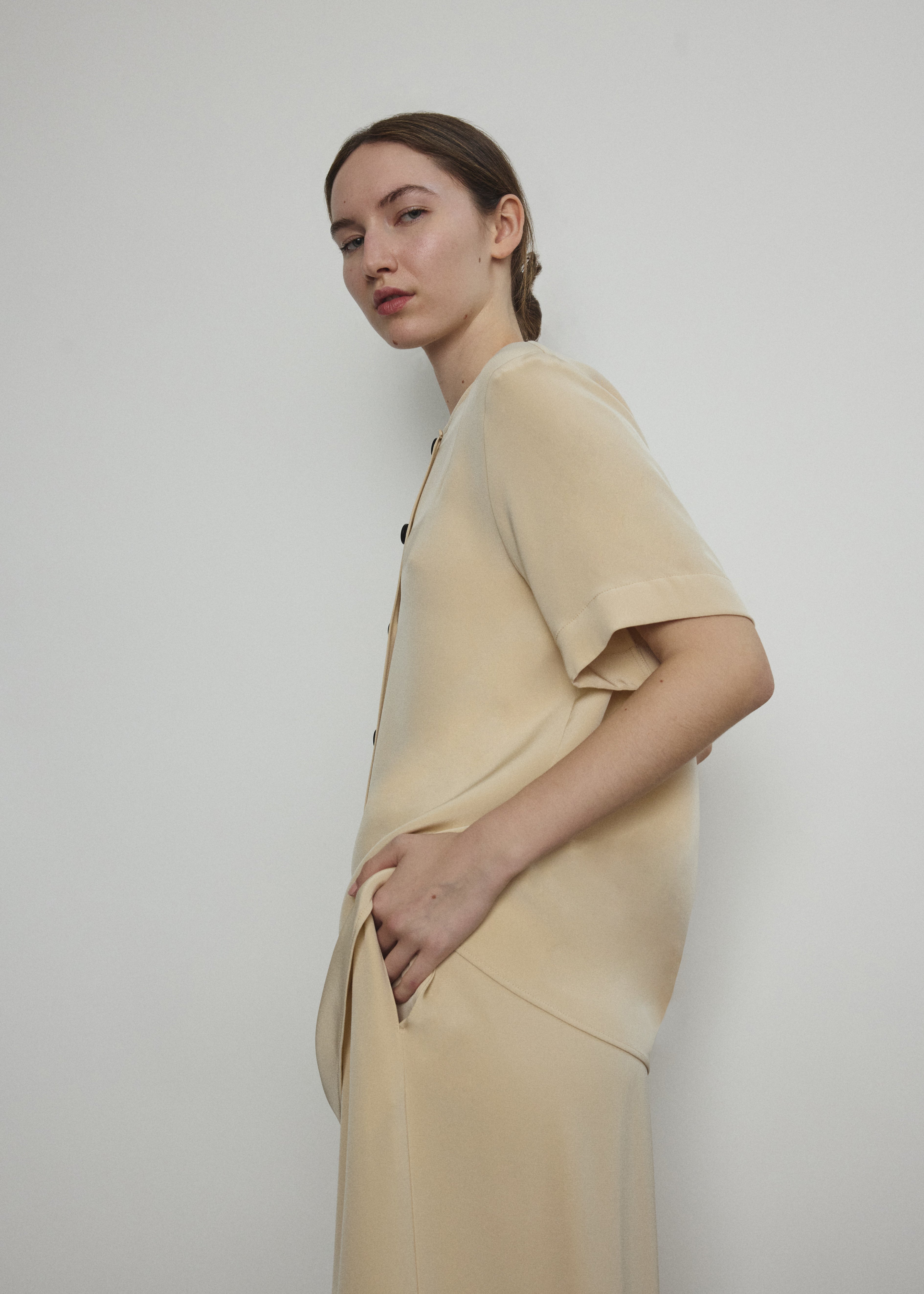 Back view of the beige silk crepe Kamperett Jette Tee showing the reversible shoulder darts.