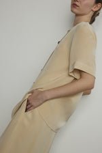 Detail of the wide button placket on the beige silk crepe Kamperett Jette Tee.