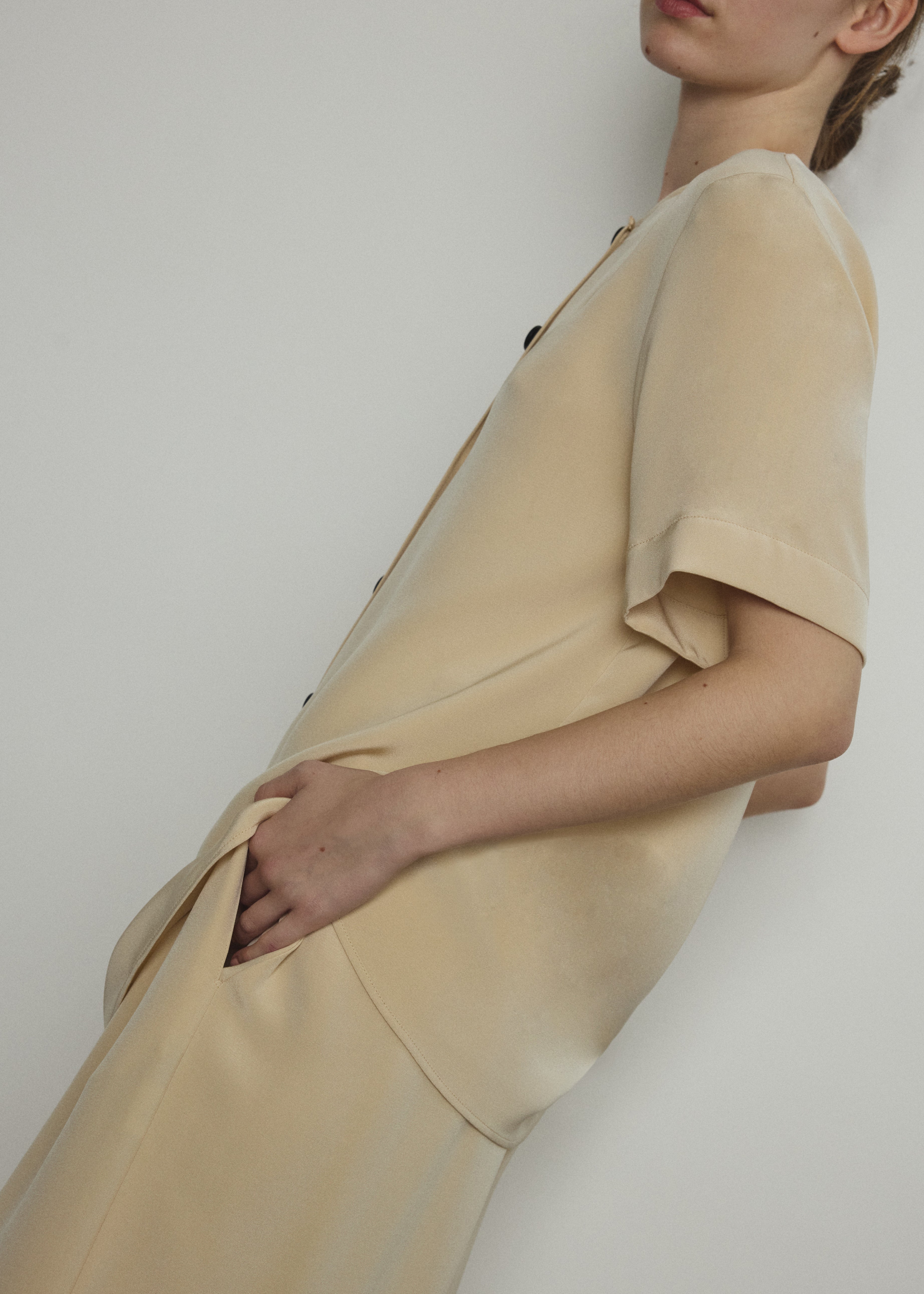 Detail of the wide button placket on the beige silk crepe Kamperett Jette Tee.